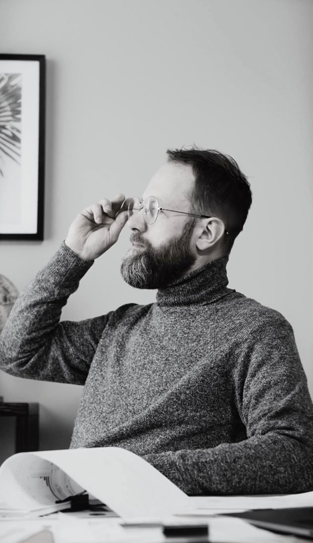 Founder behind a desk proud of the world, renown Brand Strategy we created for them