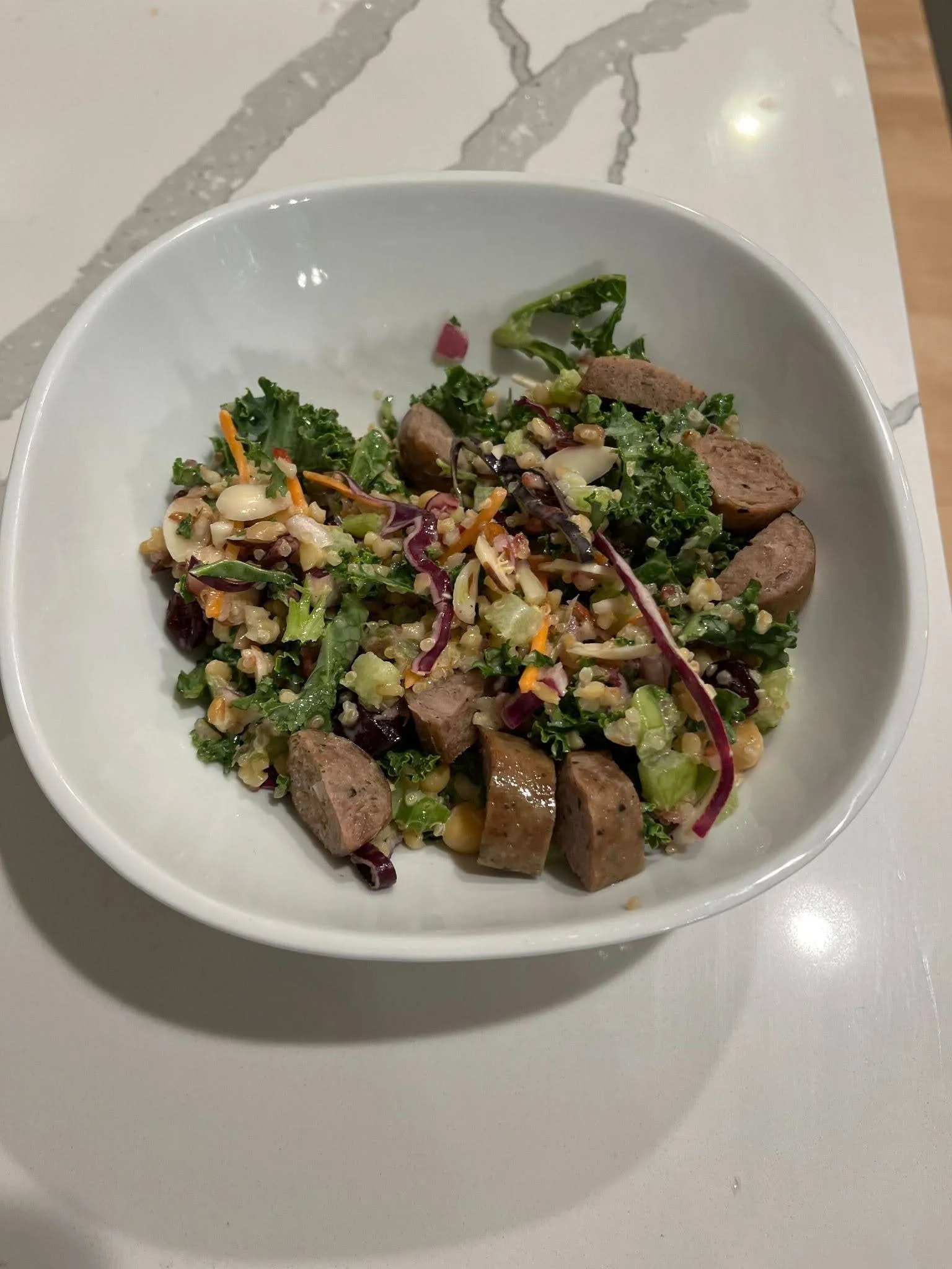 Kale and quinoa bowl with sausage — a balanced lunch to support a marathon training diet