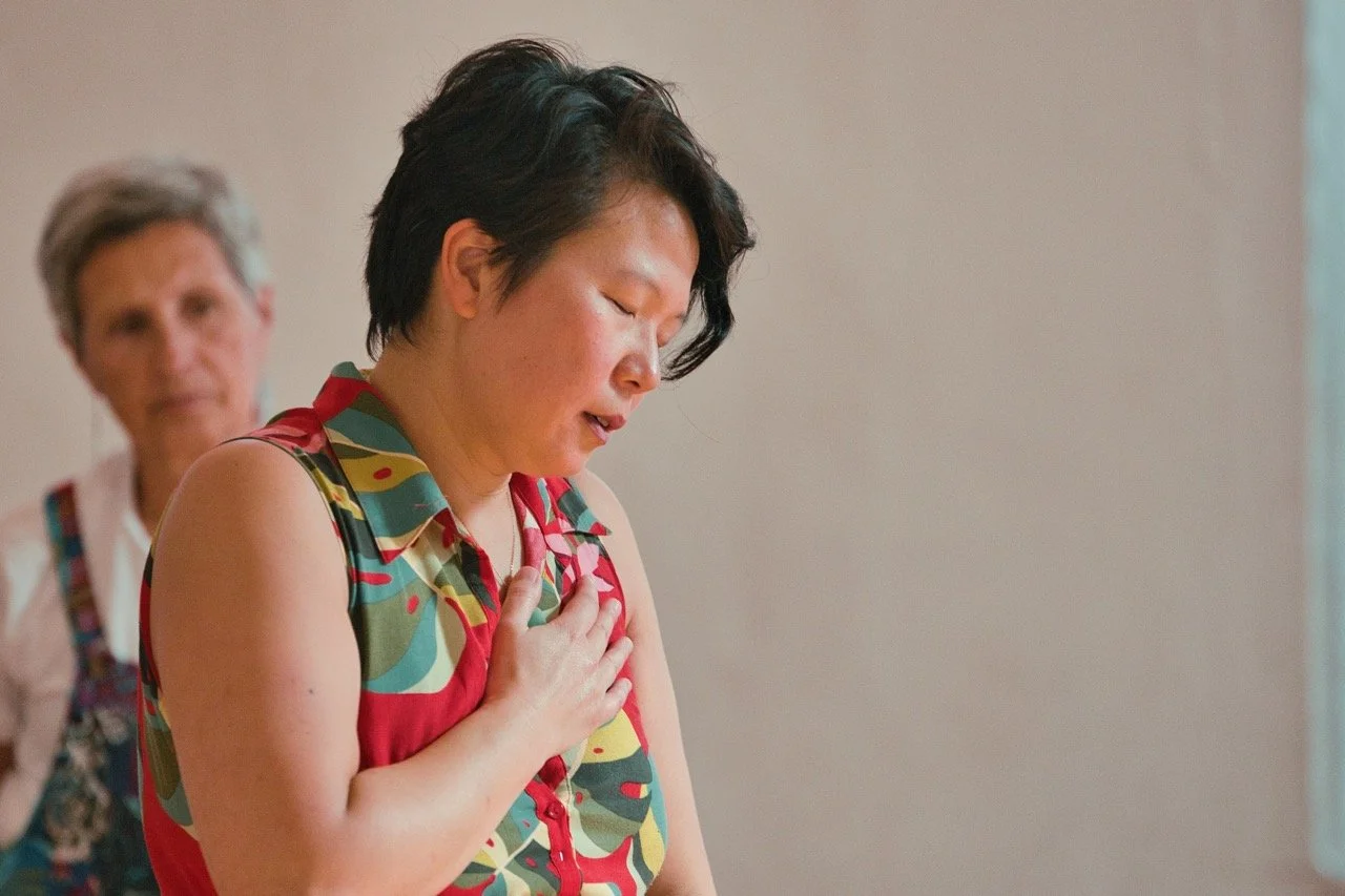 Jean Sum with her eyes closed and hand on her heart during a movement experience.
