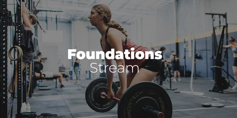 woman lifting weights in a gym with other people working out in the background