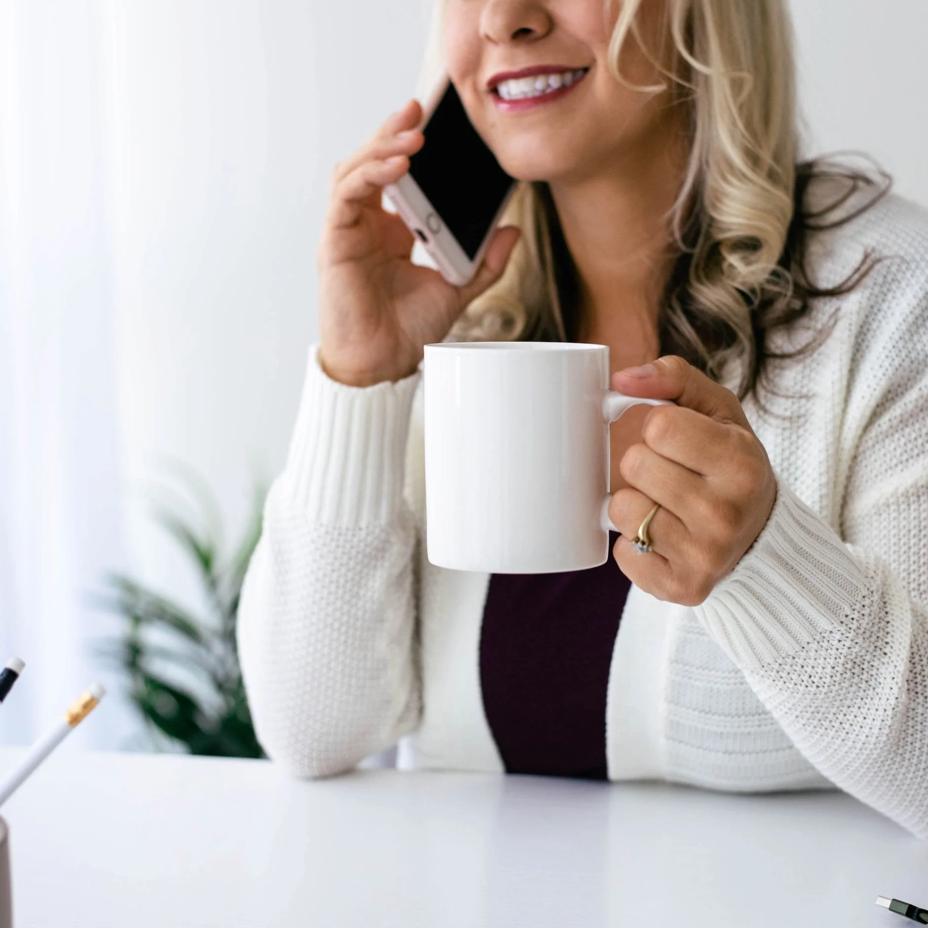 eCommerce business owner enjoying free time thanks to Pinterest passive traffic with a cup of coffee talking on her phone