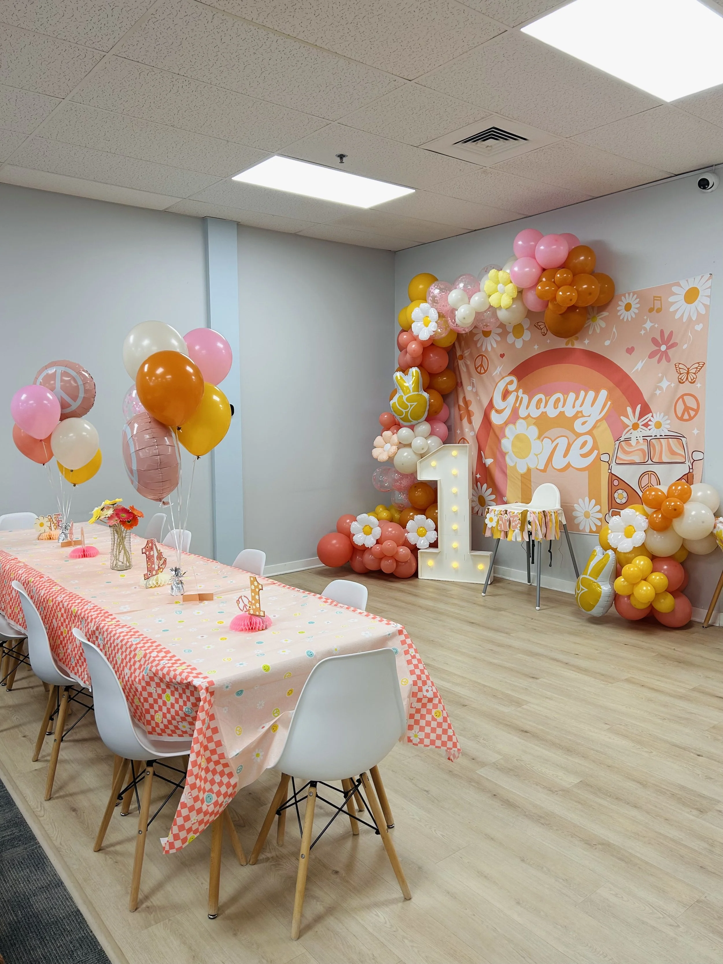 colorful decorated table for babys first birthday party. backdrop/photo op for little girls first birthday party. 