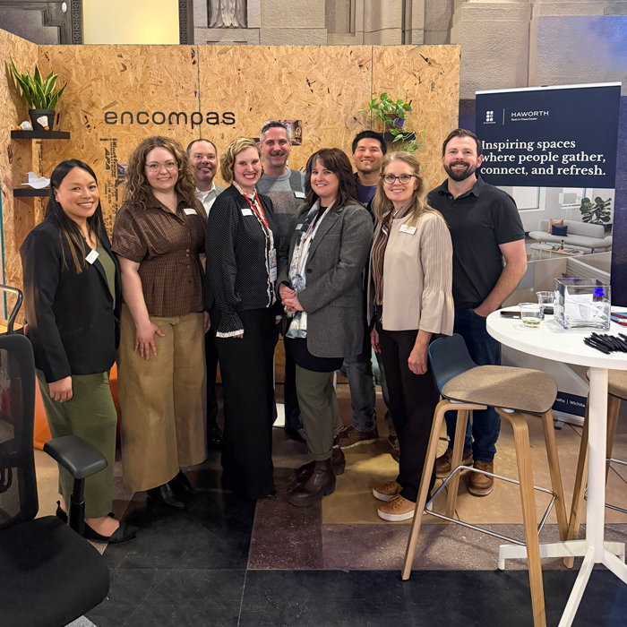 Group of people in business attire standing in front of an event booth