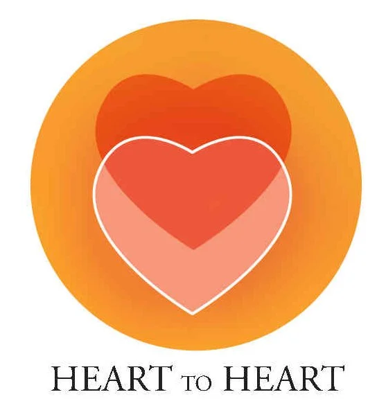 A graphic with three overlapping hearts in red, pink, and dark red, with an orange circular background. The text underneath reads 'Heart to Heart' in black capital letters.