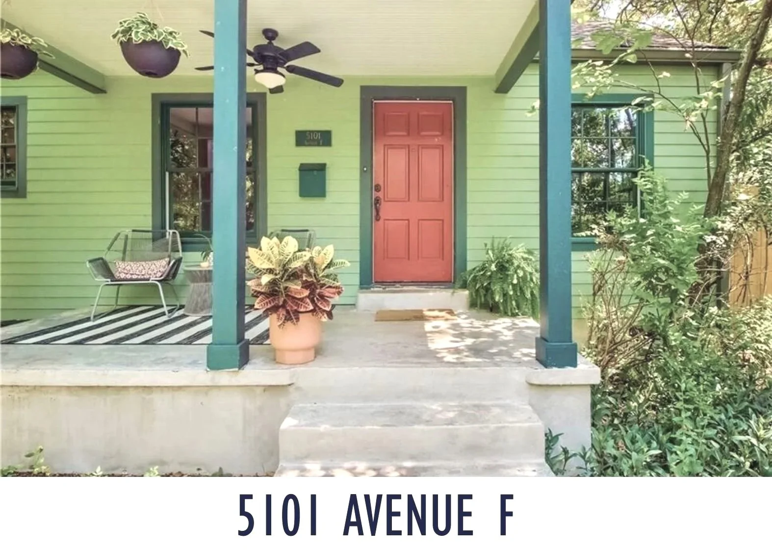 Front porch of a house with a red front door, green exterior walls, window planters, a black ceiling fan, and potted plants, with a caption reading '5101 Avenue F'.