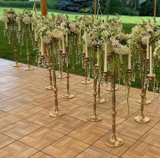 Candelabra arrangements staged to the dance floor while waiting on table linens.jpg