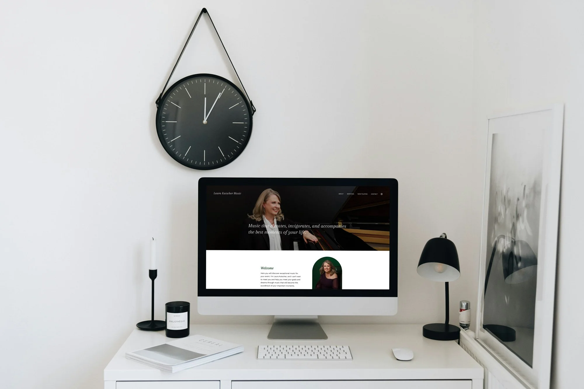 Laura Kutcher Music website on computer on black and white minimalist desk