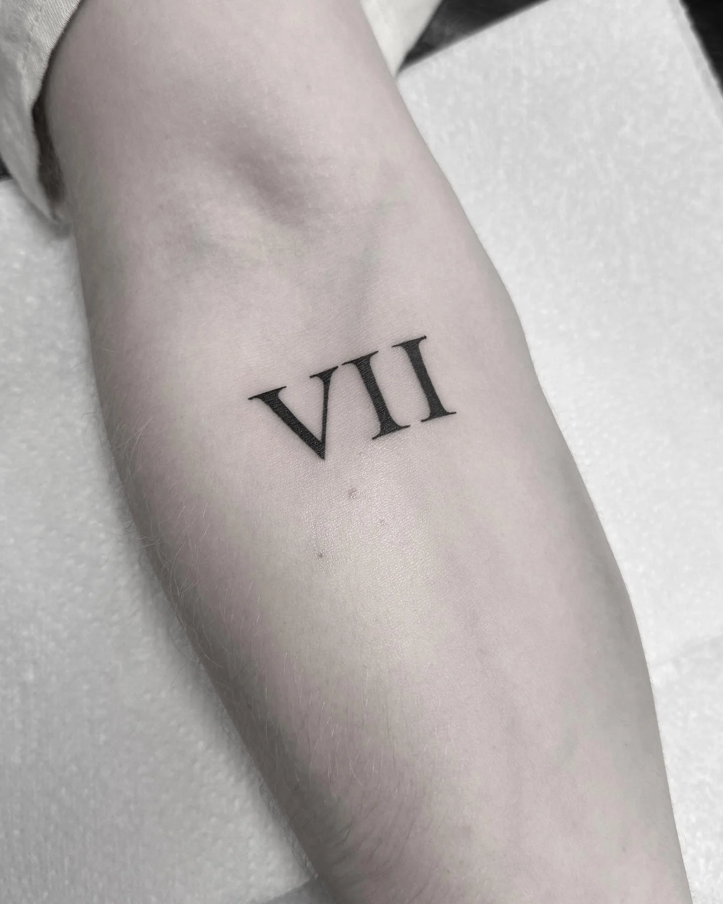 Simple script Roman numerals tattoo