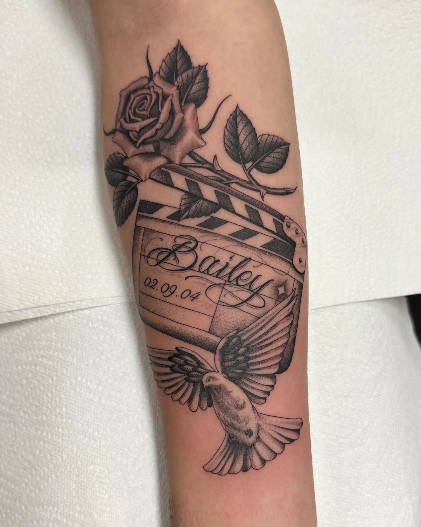Fineline black and grey film clapper rose dove tattoo