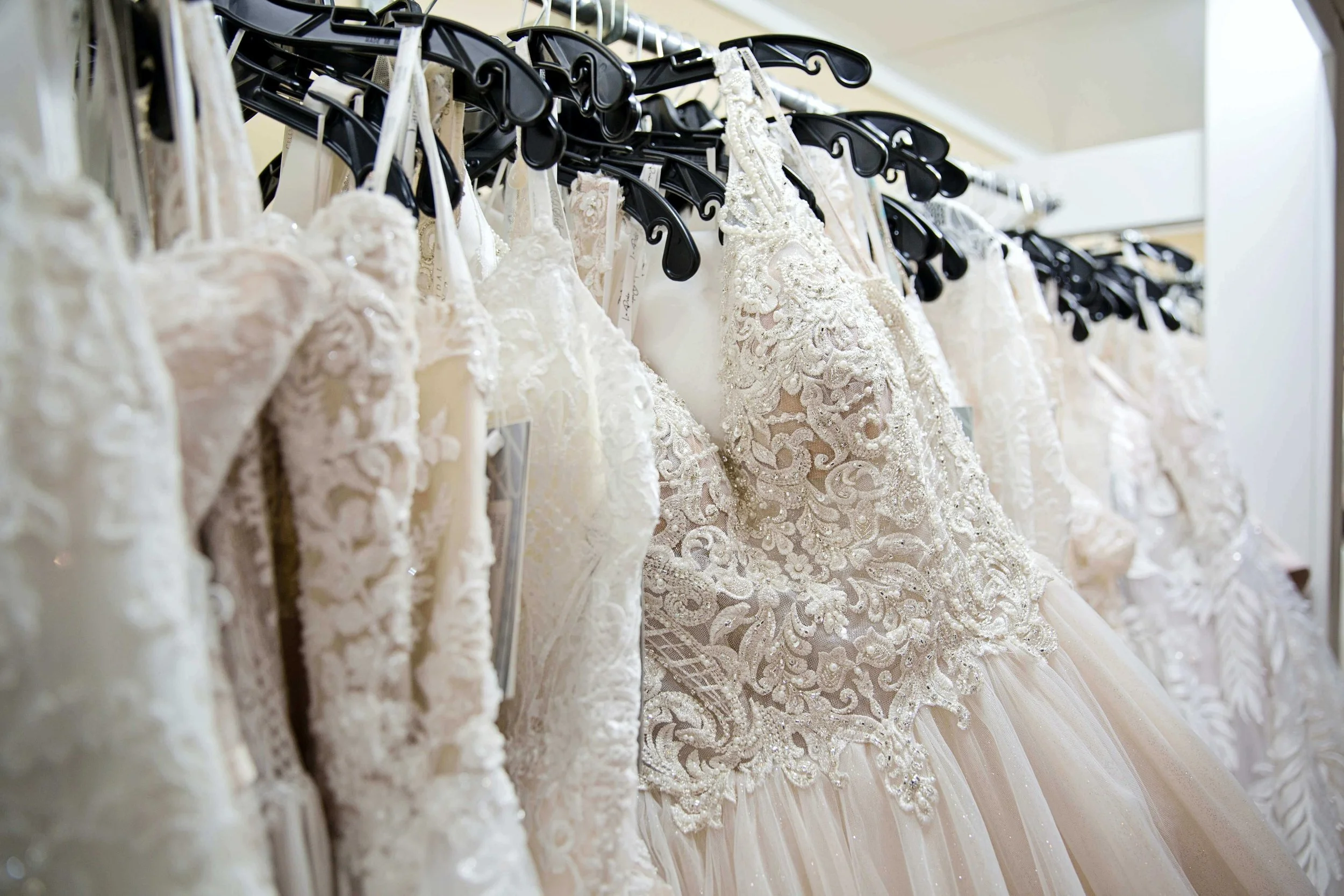 A rack of wedding dresses at a bridal store.