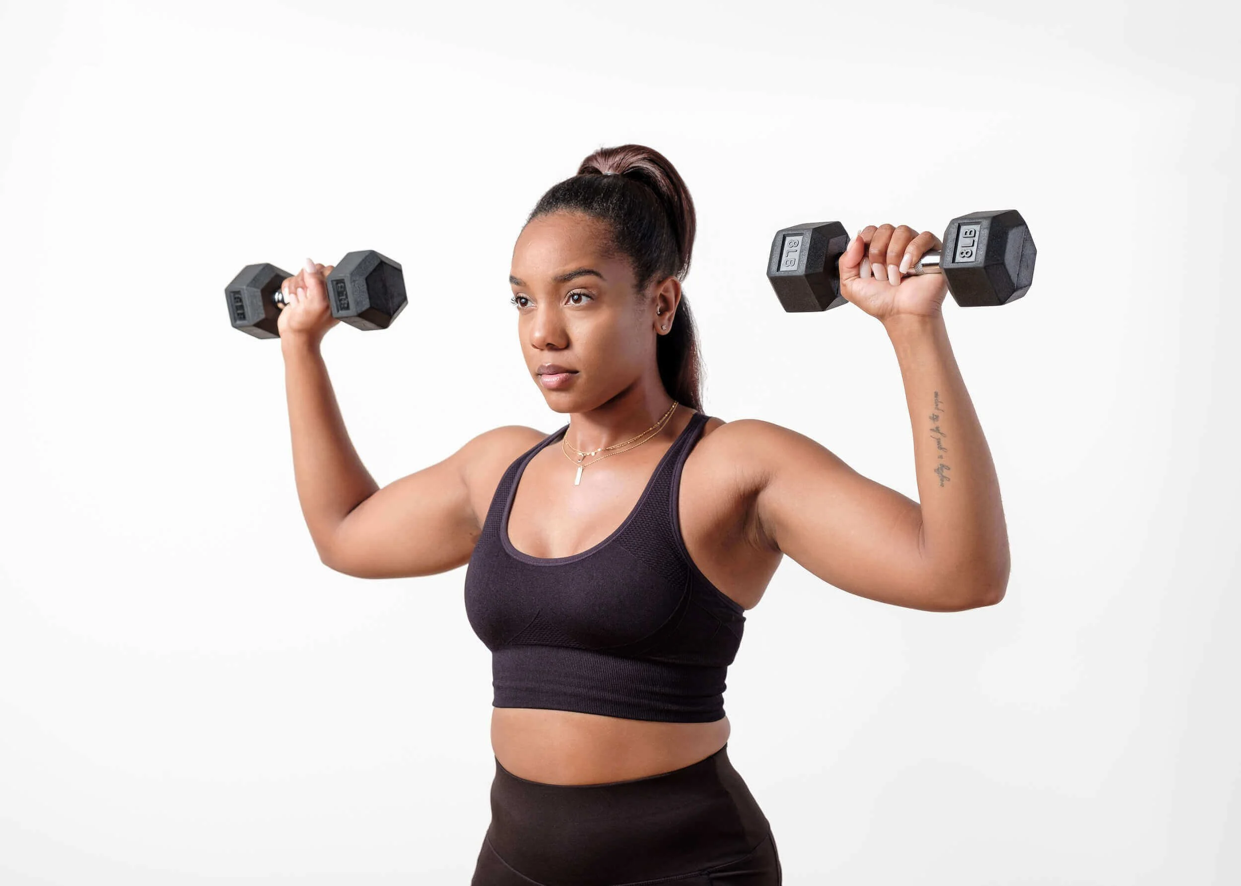 A woman performing strength training with dumbbells in a private gym setting, representing structured bridal fitness preparation in San Francisco.