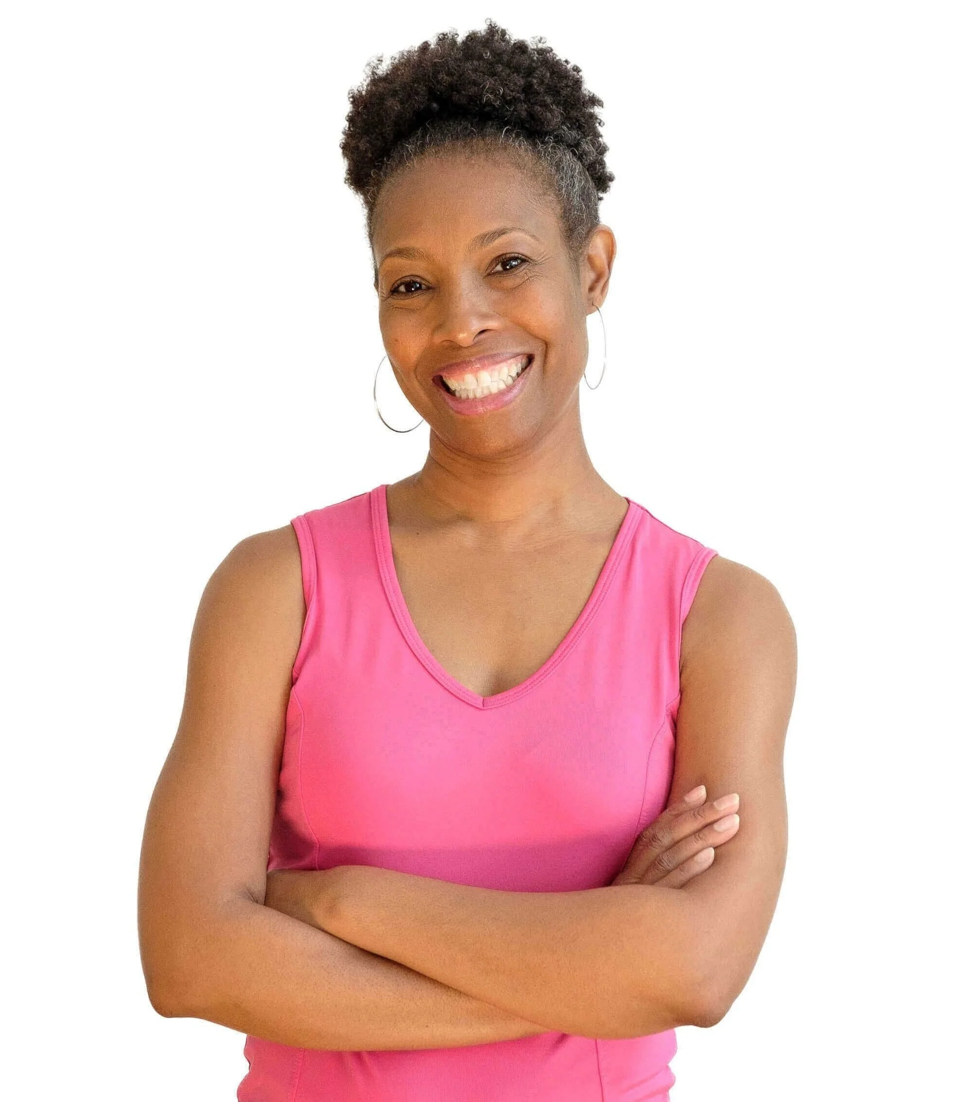Smiling woman with crossed arms wearing a pink sleeveless top against a white background.
