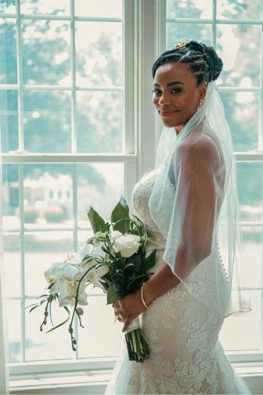 Woman standing by window in wedding dress