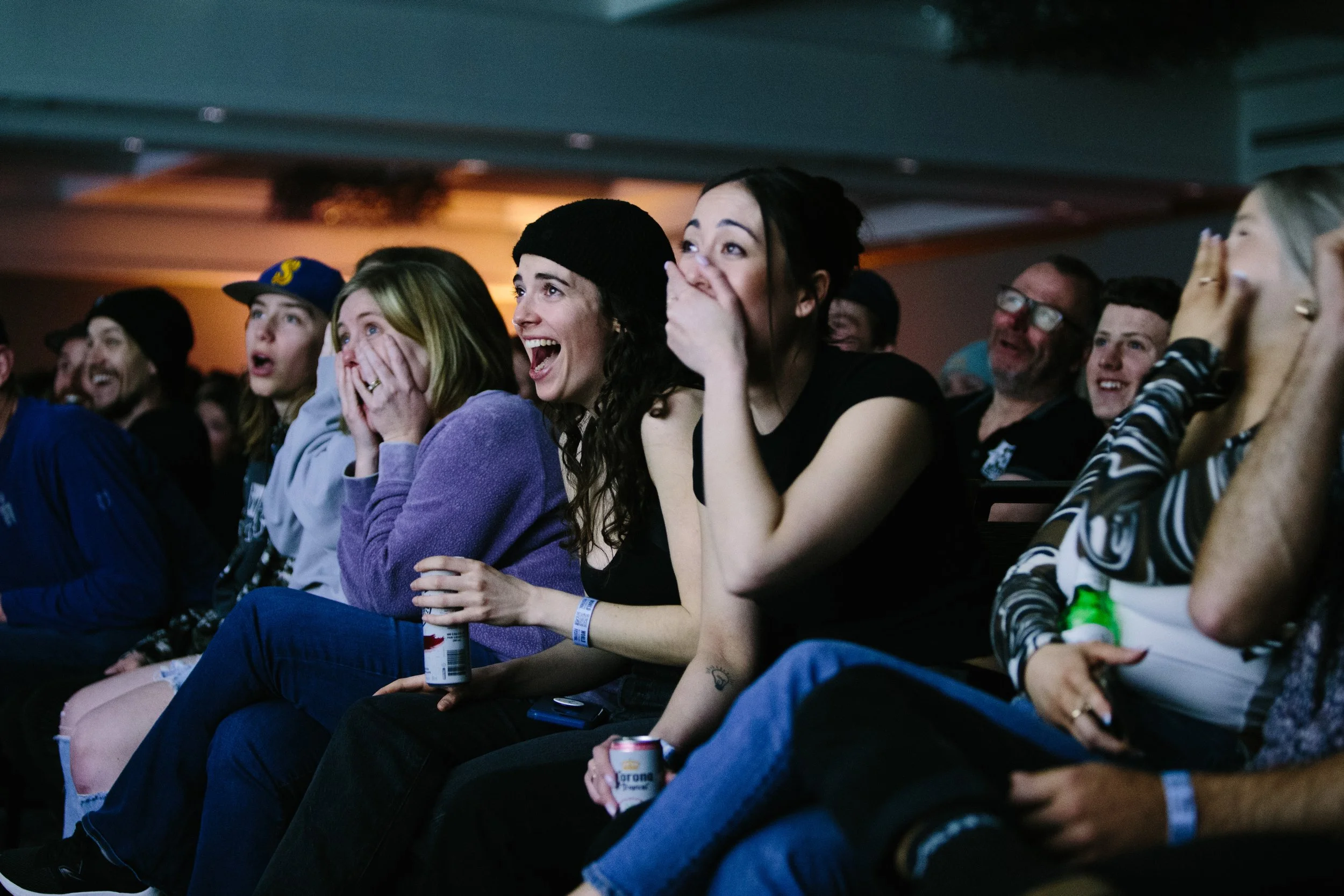 Audience at an event reacting with surprise and laughter.
