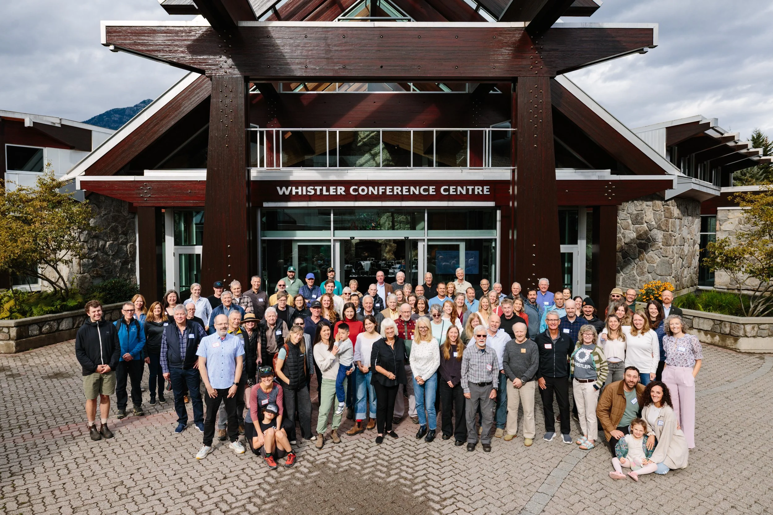Group of people posing outside the Whistler Conference Centre for a photo.