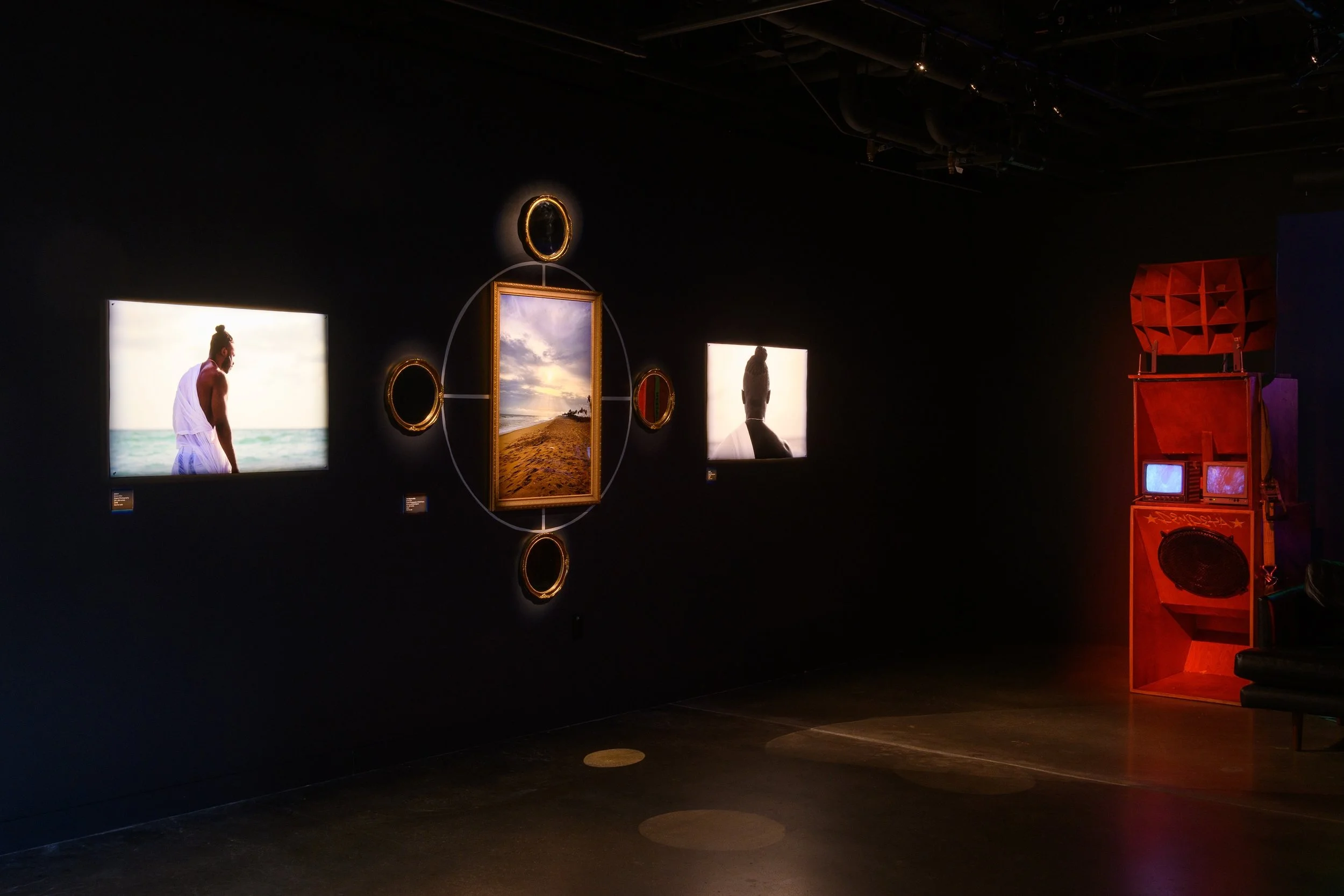 Front left to right: Ehime Ora, "Amé I," 2018, Digital Photography, 24 x 36 inches. "The Return of Us," 2024, Digital Photography in Gold Frame, Mirrors and Cosmogram, 50 x 60 inches. "Amé II," 2018, Digital Photography, 24 x 36 inches. Photo by Raym