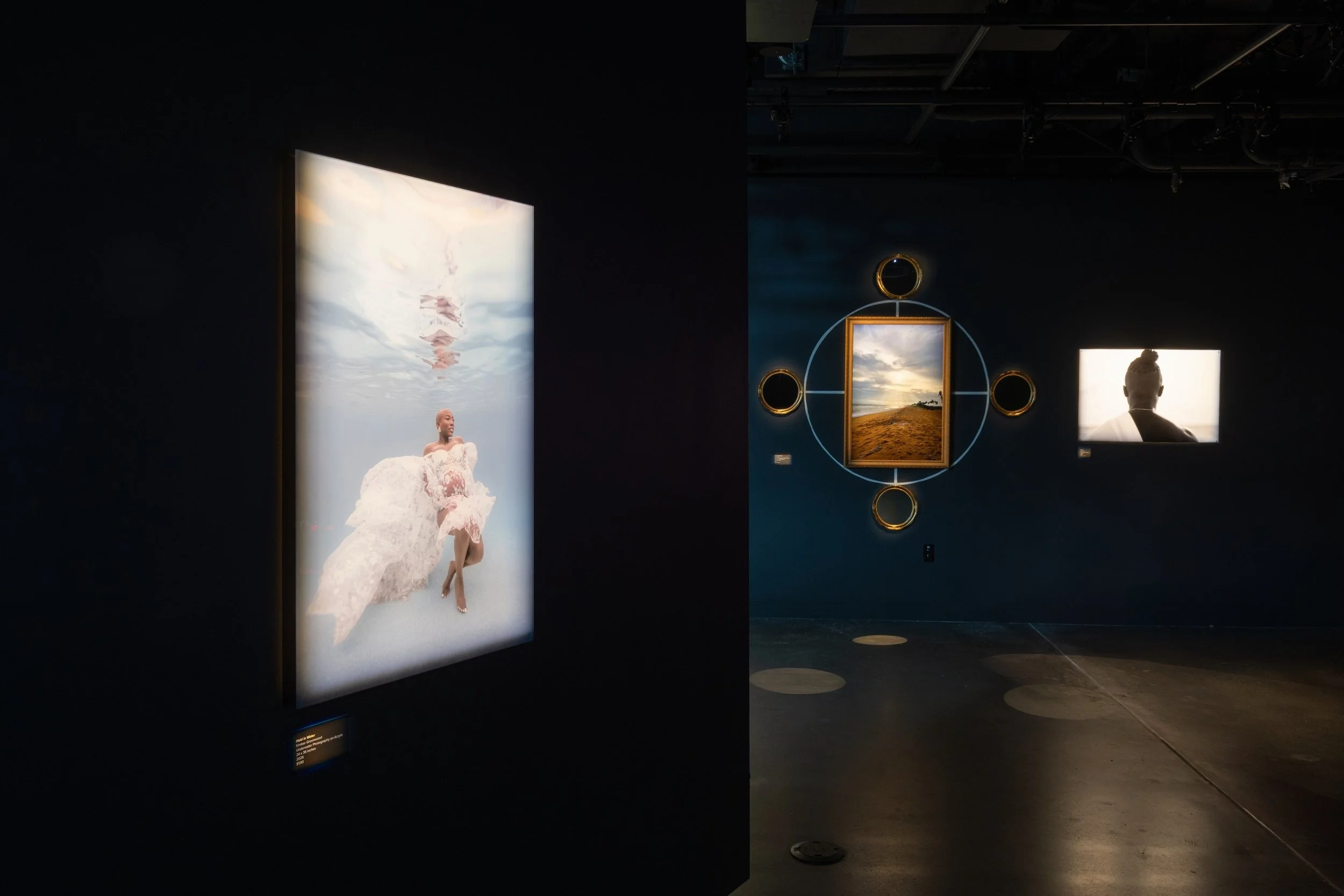 From left to right: Kimber Greenwood, "Held in Water" 2025, Photography on acrylic, 24x36. Ehime Ora, "The Return of Us," 2024, Digital Photography in Gold Frame, Mirrors and Cosmogram, 50 x 60 inches. "Amé II," 2018, Digital Photography, 24 x 36 inc