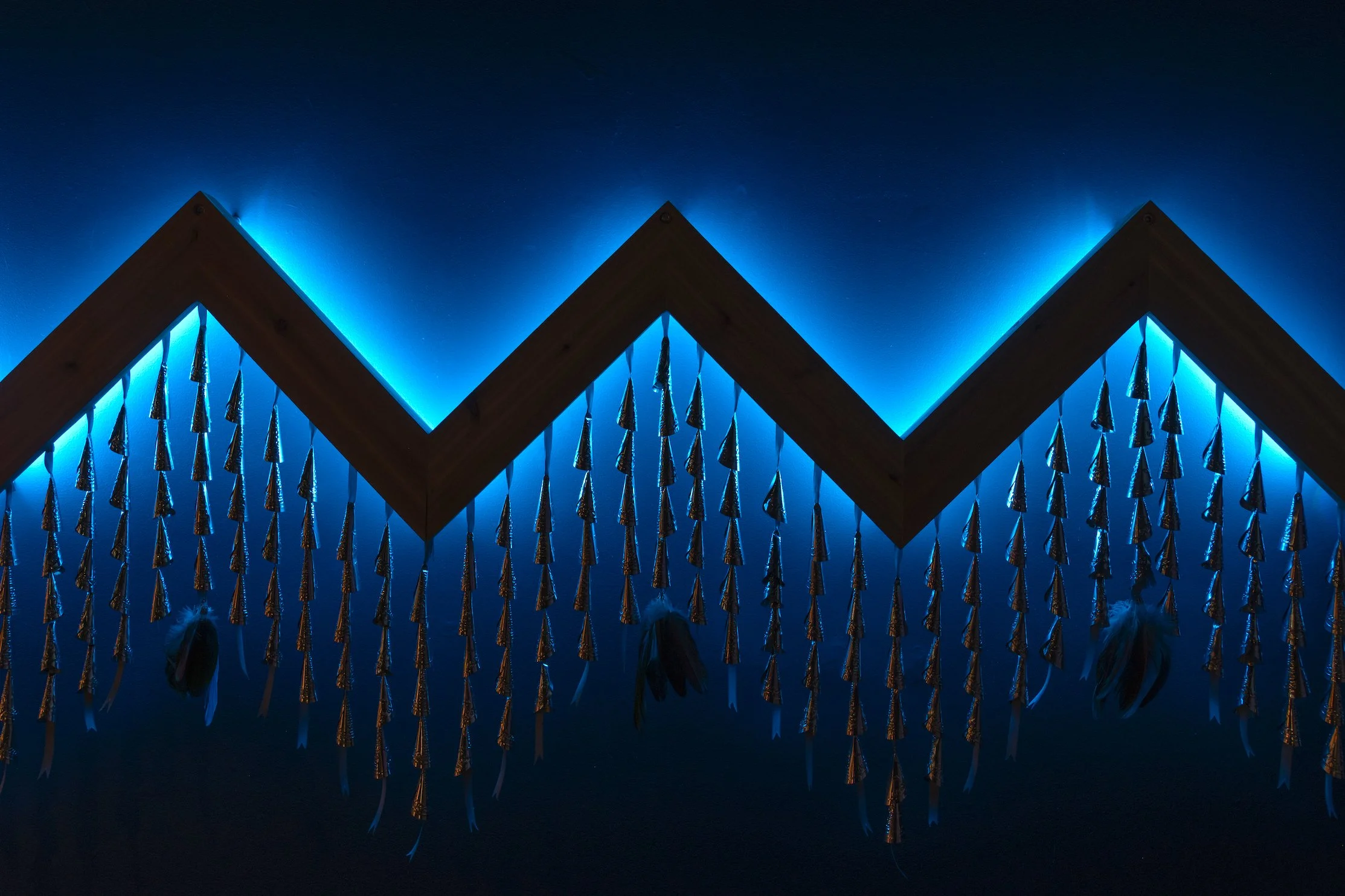 JayCee Beyale, "Atsiniltł'ish (Lightning)," detail 2025, Cedar wood, LED lights, ribbon and jingle cones, 10.5′ x 2′ x 6′.