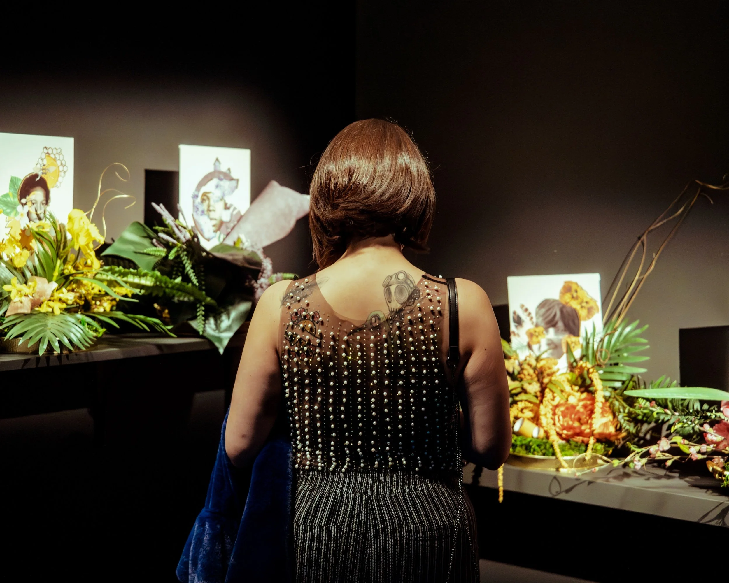 Visitor engaging with Yazz Atmore's, "Women We Call Home," 2021, Floral Collage Series, 12 x 12 inches each. Photo by Helen Yoseph.