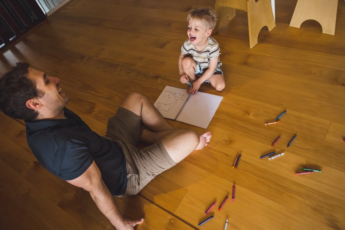 Child and dad drawing together