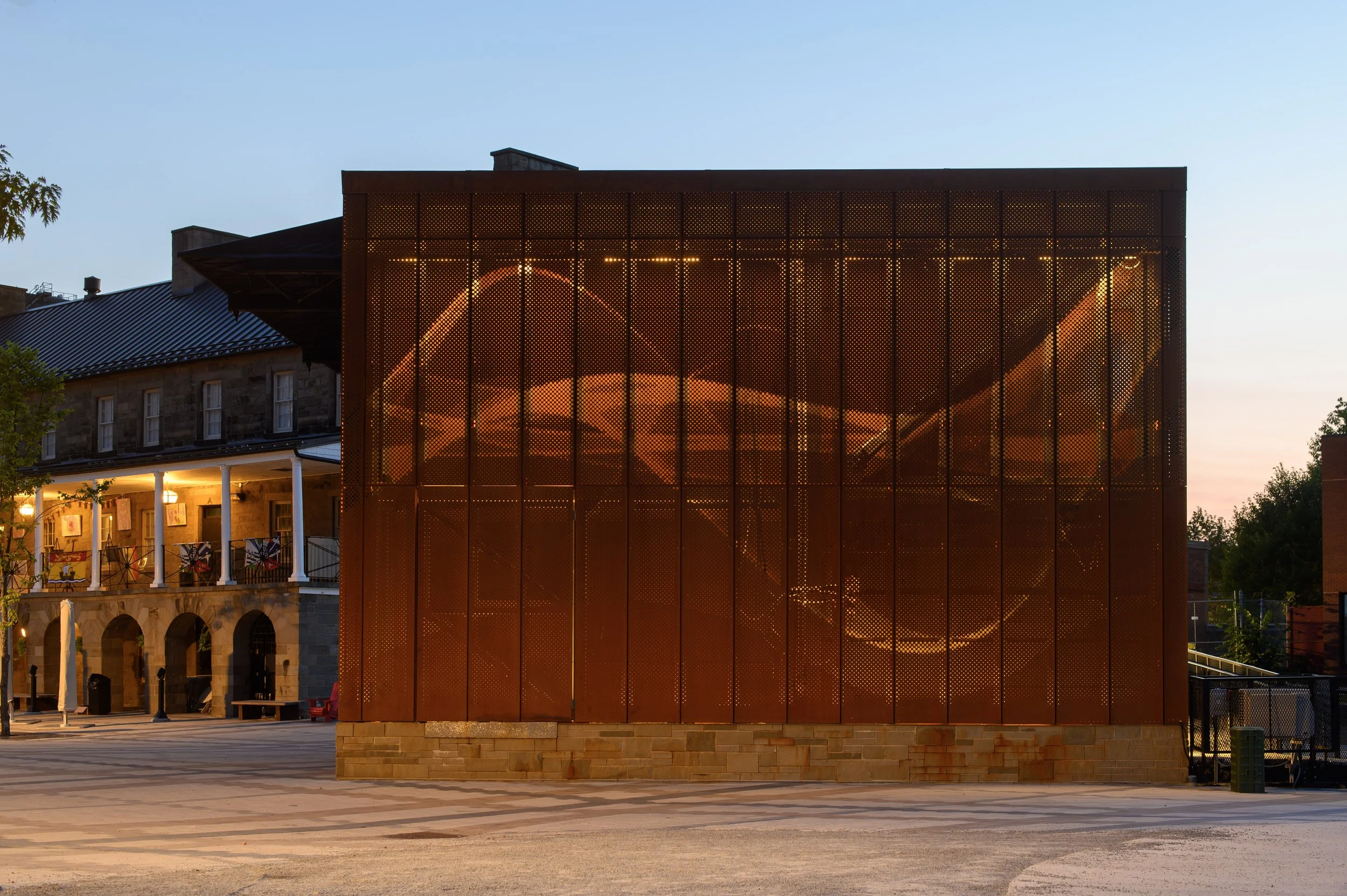 Custom perforated COR-TEN weathering steel facade on the Garrison Stage civic pavilion in Fredericton, New Brunswick.