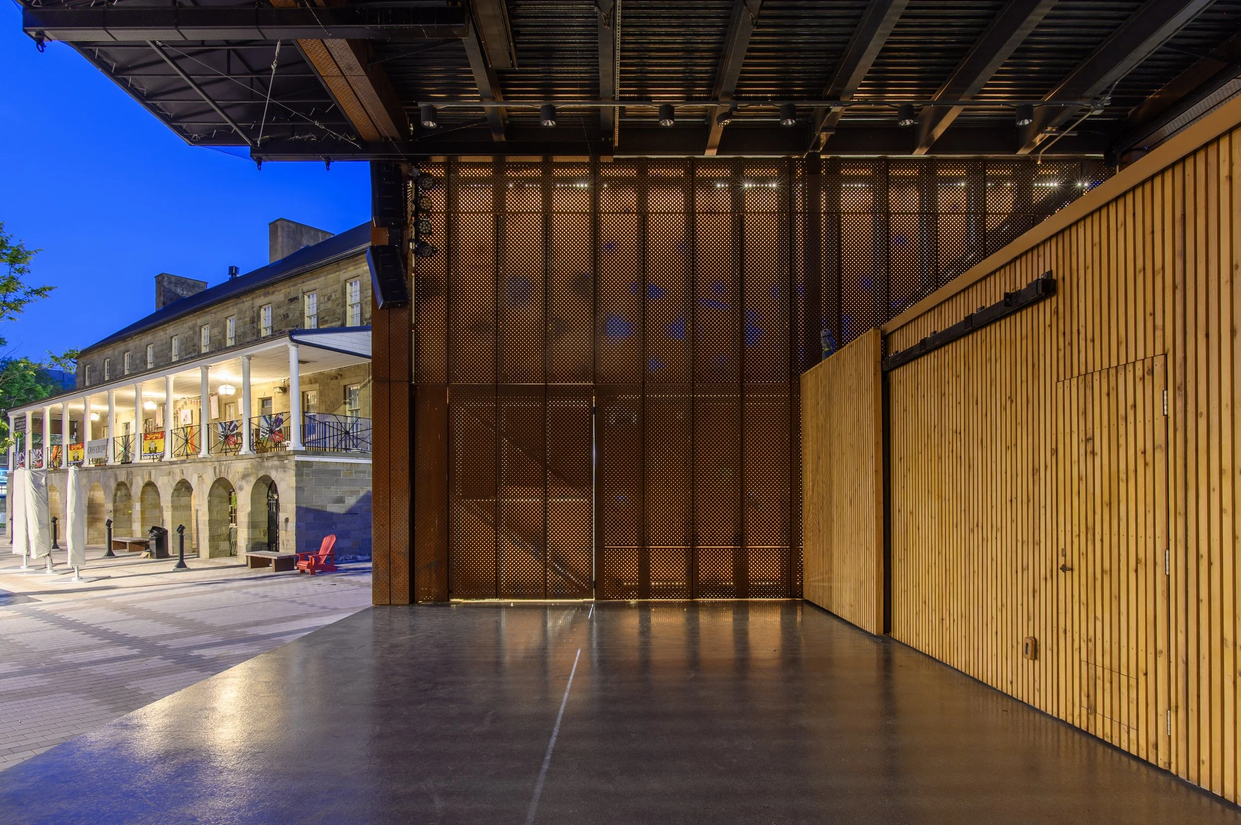 Custom perforated COR-TEN weathering steel facade on the Garrison Stage civic pavilion in Fredericton, New Brunswick.