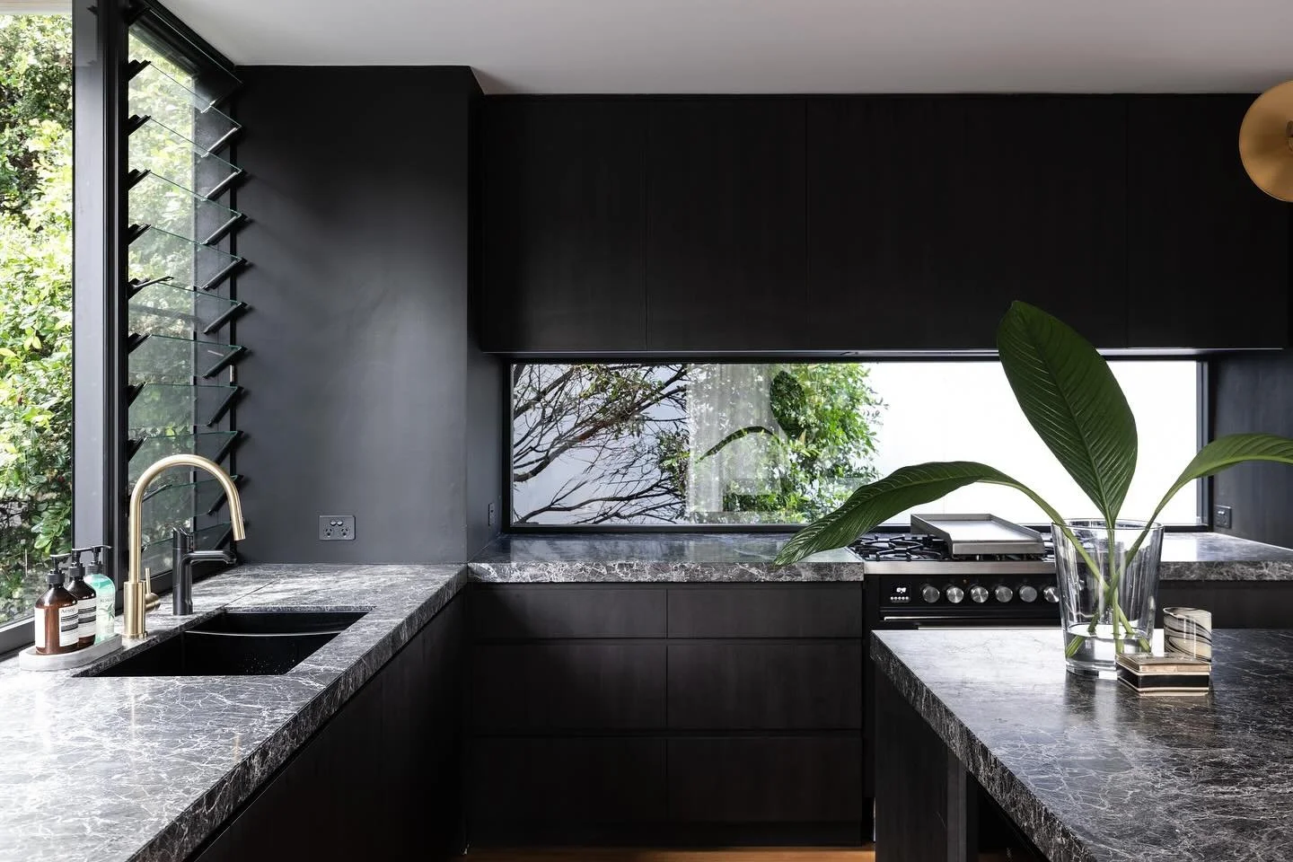 A black stained timber kitchen contrasts the light-filled living areas at our recently completed Queenscliff project. Builder: @urban_impact Photos: @simonwhitbreadphoto #watershedarchitects