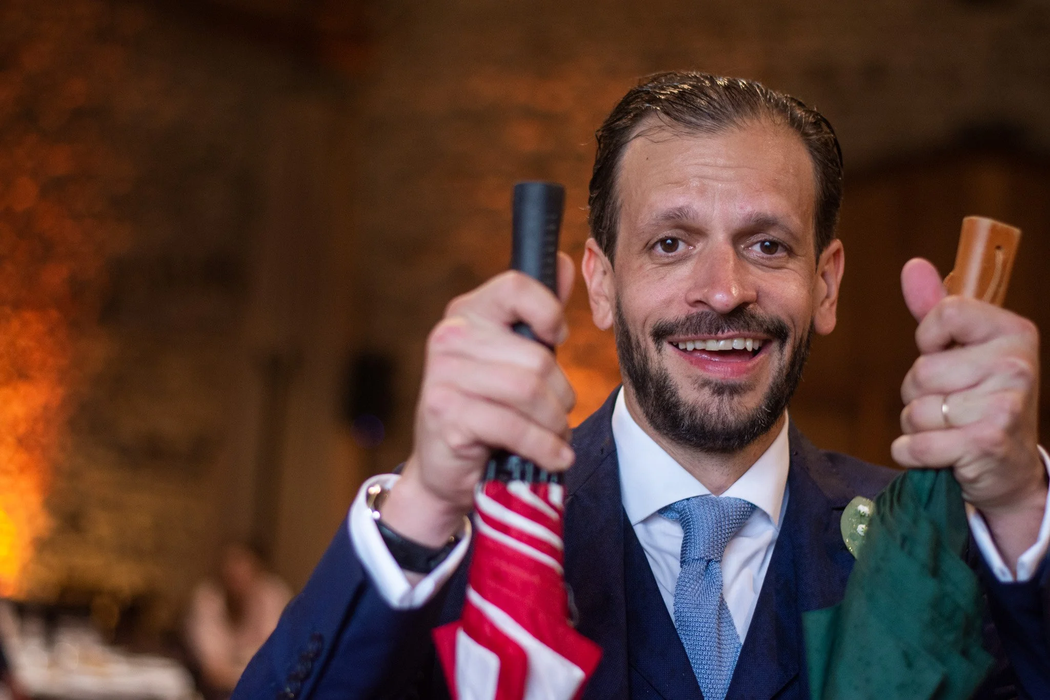 invité tient 2 parapluies sourit après orage mariage Beaujolais.jpg