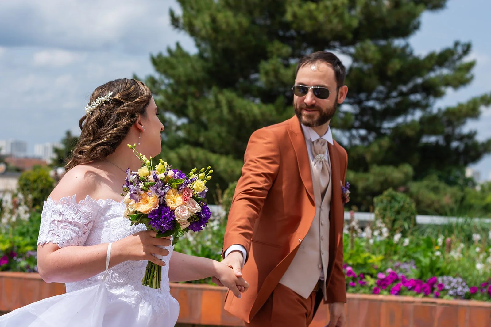 couple de mariés qui se tient par la main en se regardant