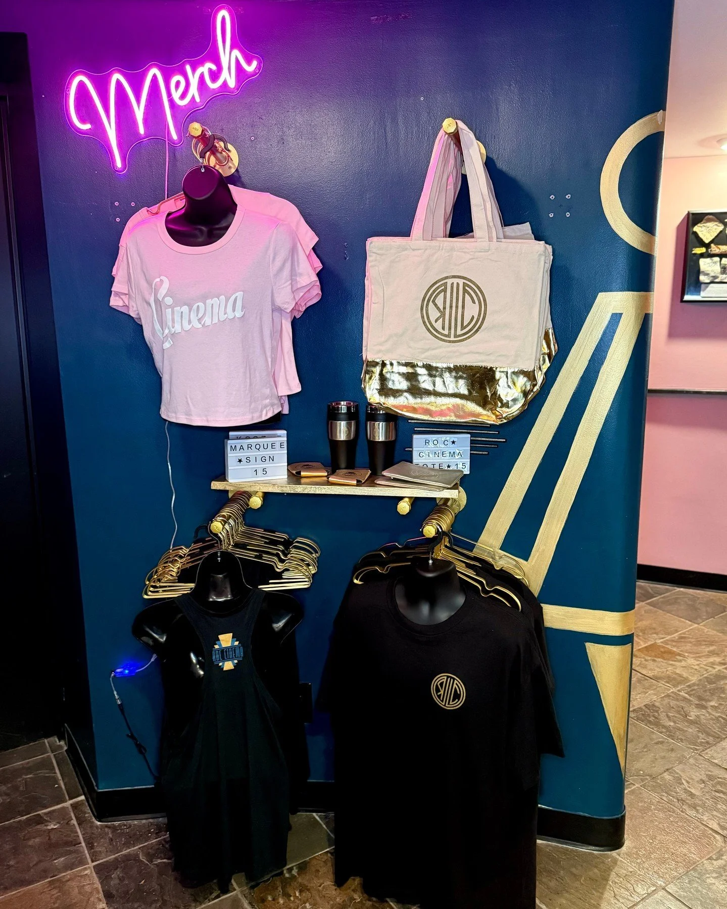 Check out our new merch wall! 🎬✨ We&rsquo;ve got tote bags, shirts, tank tops, tumblers, drink koozies, mini light-up marquees and pouches. Grab some gear and show your support for ROC Cinema&mdash;every purchase helps us keep bringing you the movie