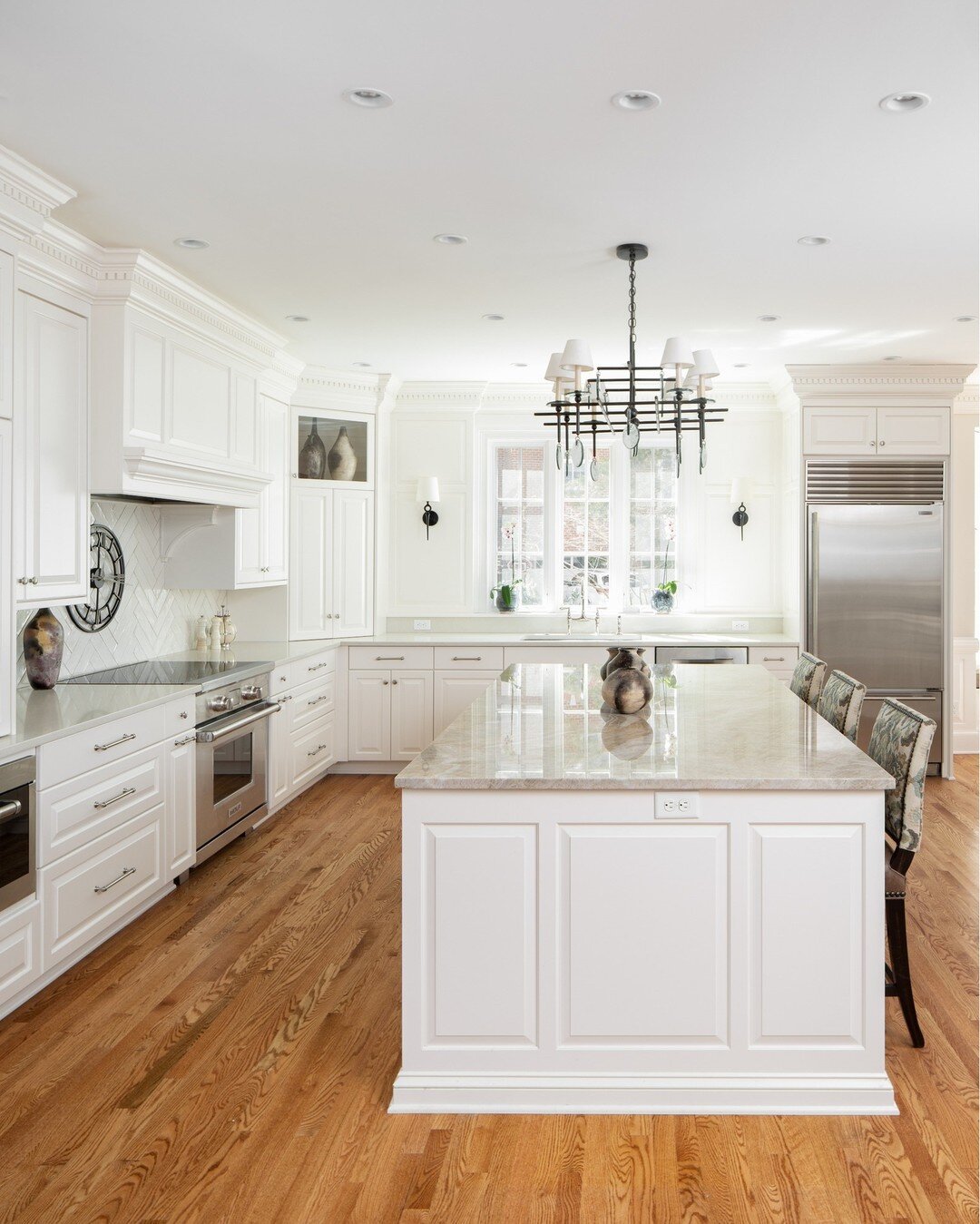 White design elements easily reflect natural light, making this luxurious kitchen feel and appear more spacious.