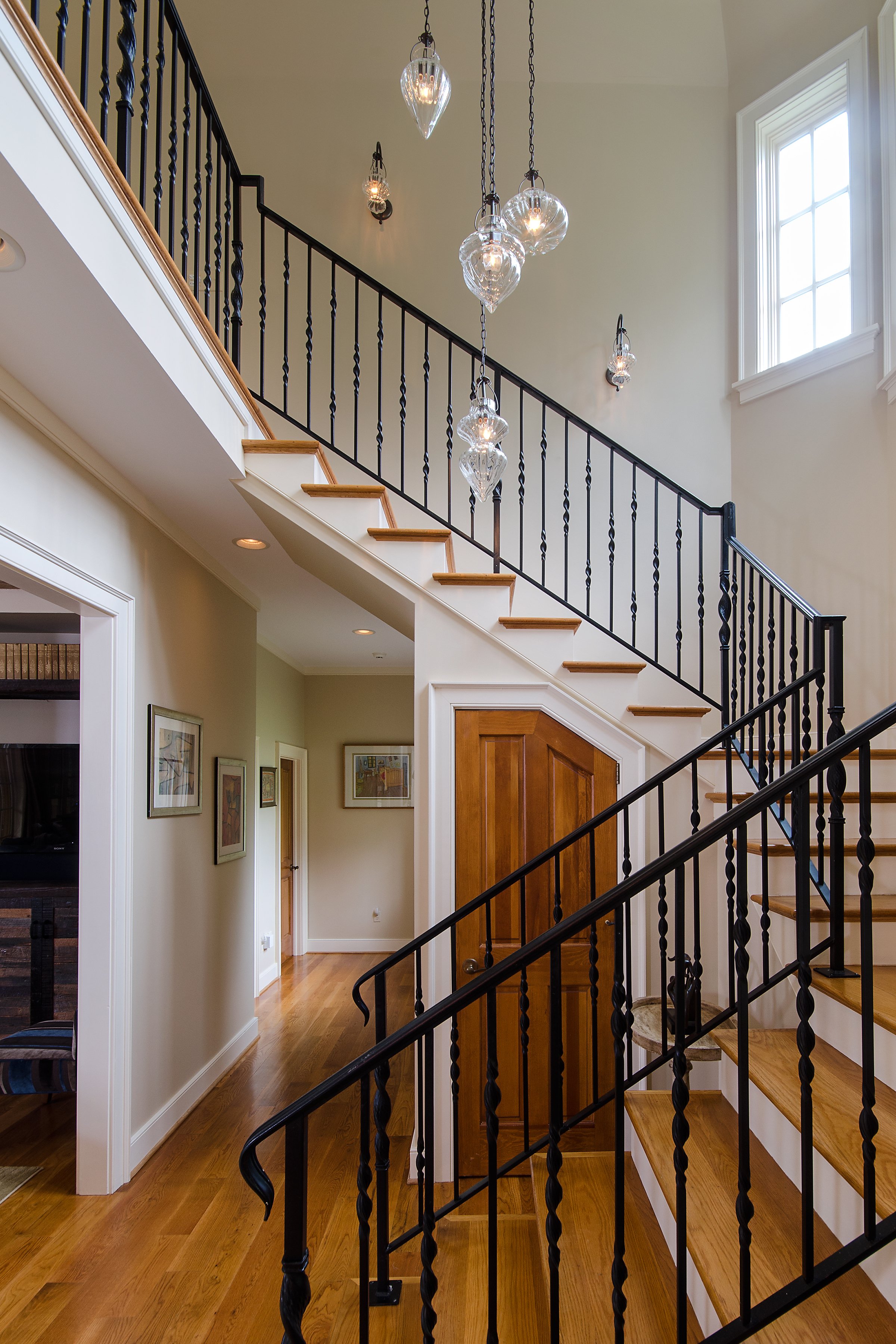 Staircase with warm tones and black banister