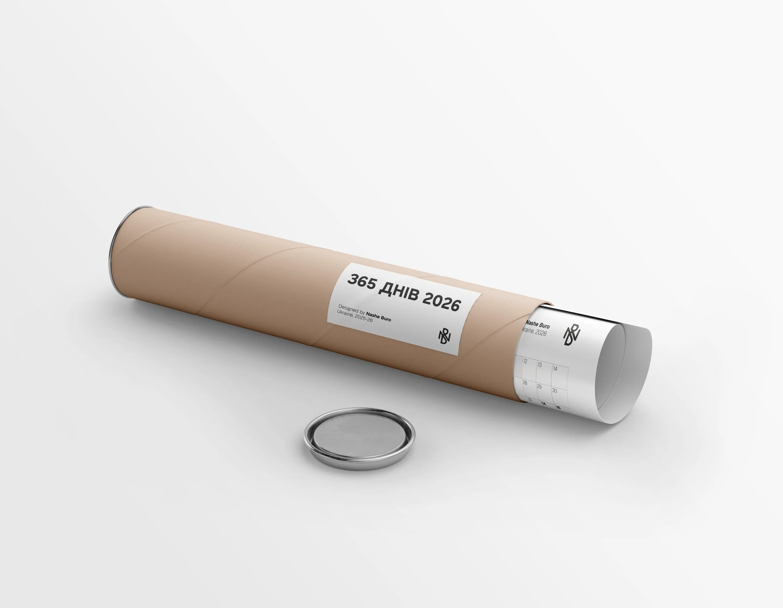 A rolled-up calendar for the year 2026 with the title in Ukrainian, indicating 365 days, lying on a white surface. There is also a silver ring in front of the calendar.