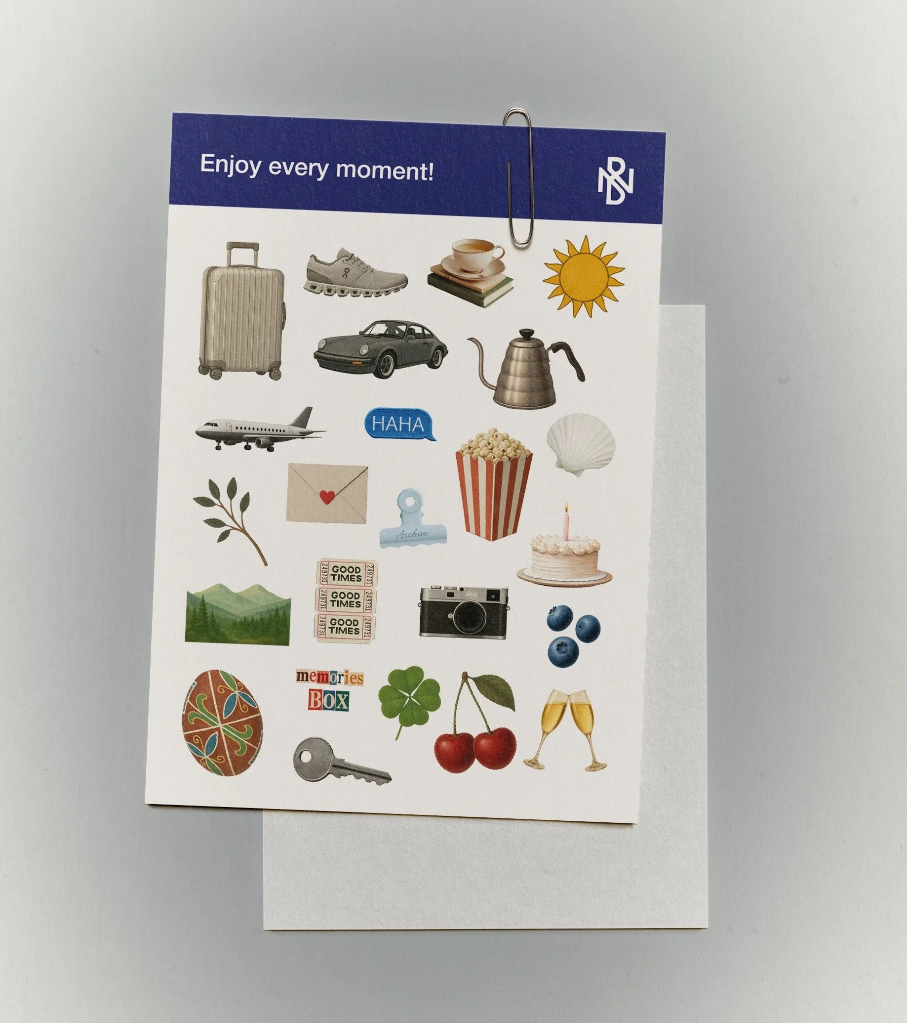 A collection of various images including a suitcase, sneaker, teacup, sun, car, teapot, airplane, speech bubble with 'HAHA', envelope with a heart, popcorn, shell, branch, adhesive clips, mountain scene, 'Good Times' stickers, camera, blueberries, decorated chocolate egg, four-leaf clover, cherries, champagne glasses, a key, and a birthday cake.