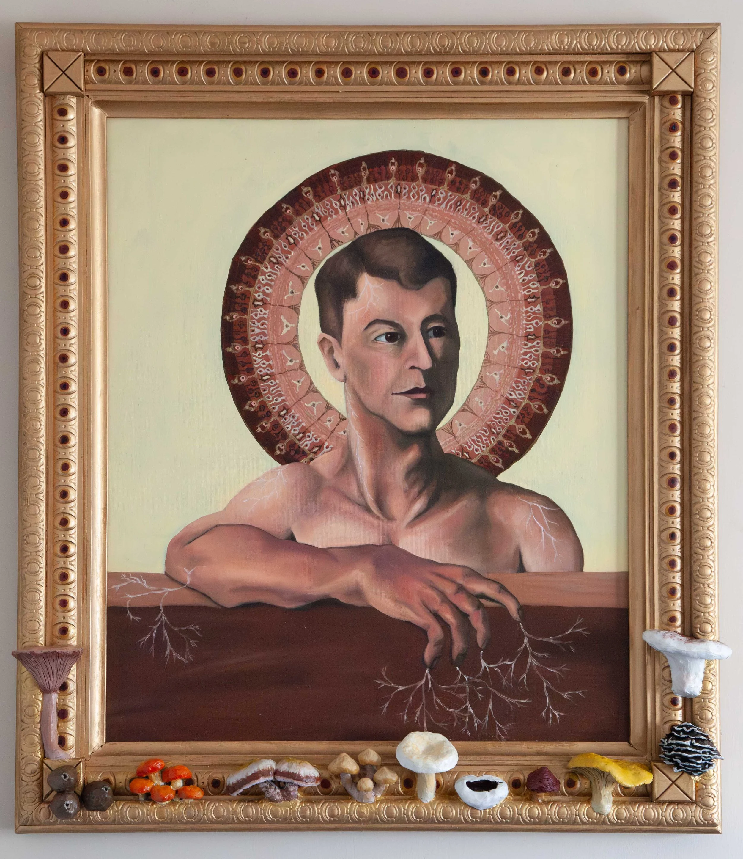 Icon of a nude man with a halo made of the iris of an eye rests his arm on a wooden wall. Mycelium sprouts from his body and melds into the wood. Sculptures of mushrooms adorn the golden frame decorated with eyes.