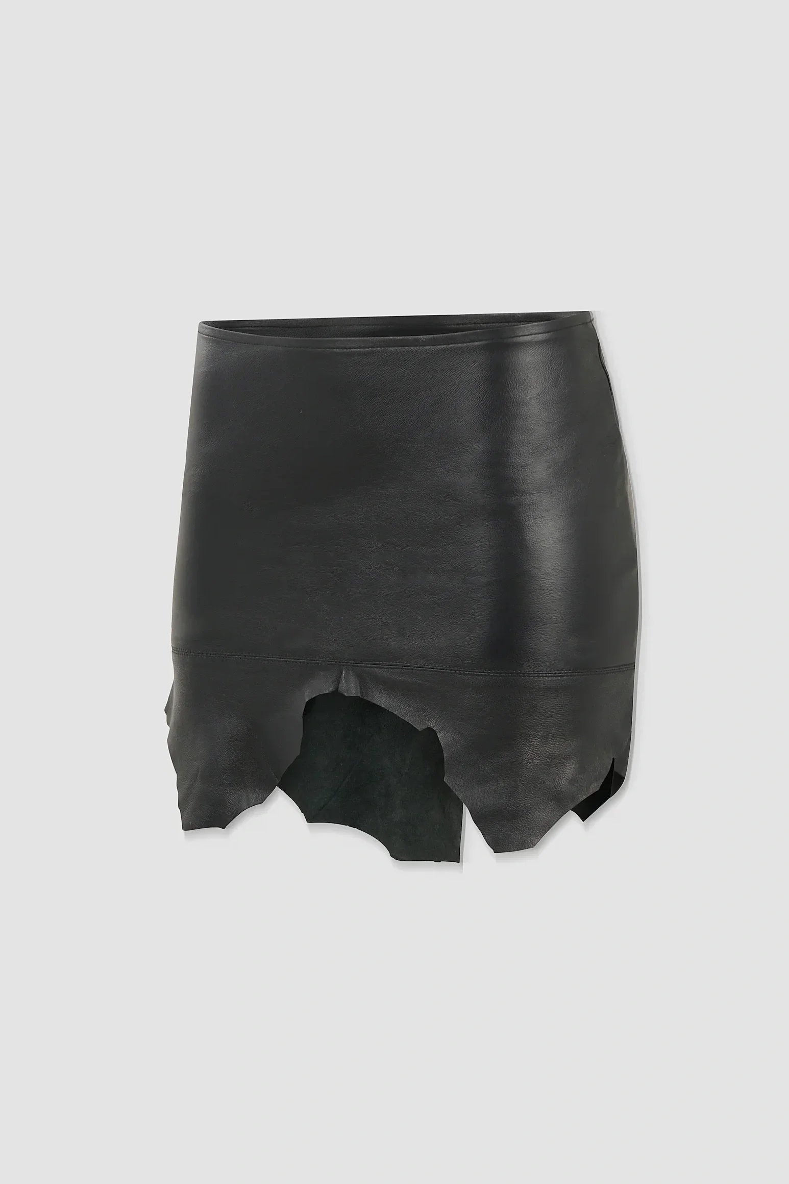 Three-quarter: Angled view of the ‘Euryale’ leather micro mini skirt showing the panelled construction and irregular leather edges.