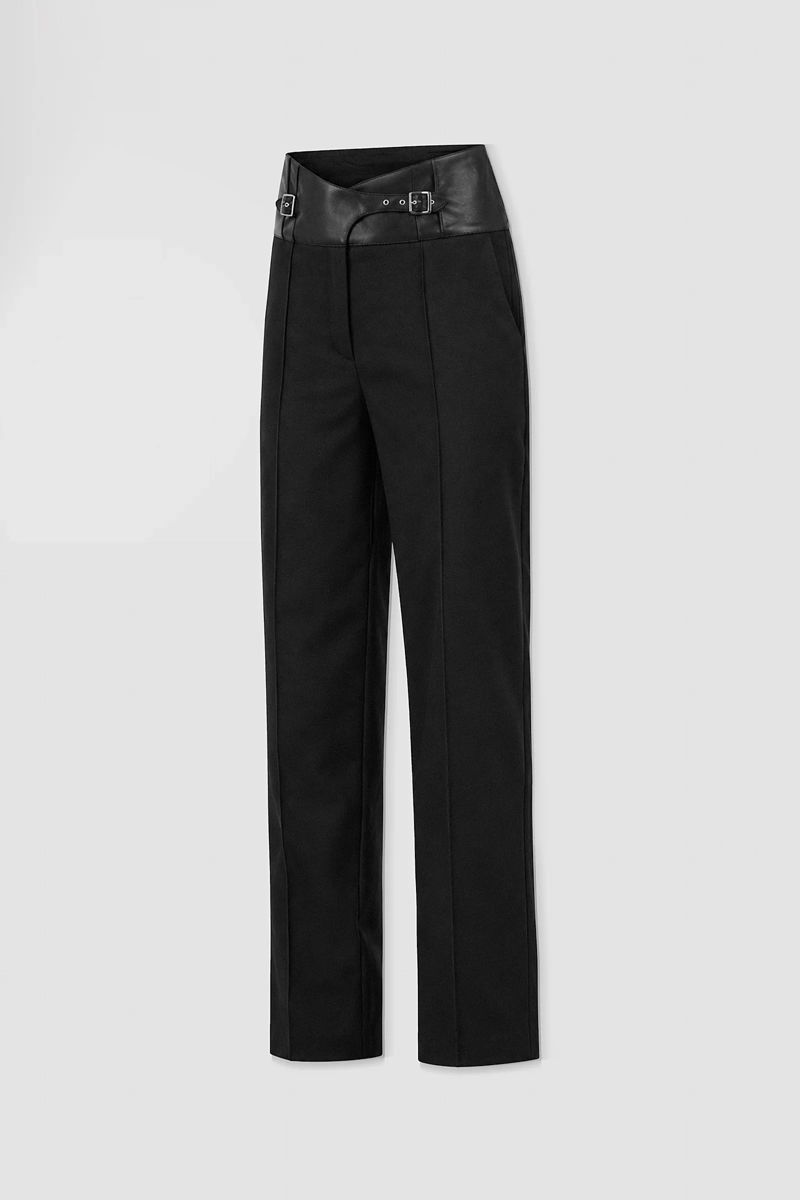Three-quarter view of ARAKHNE black wool and leather trousers showing the crossover waistband, buckle detailing and straight-leg tailoring.