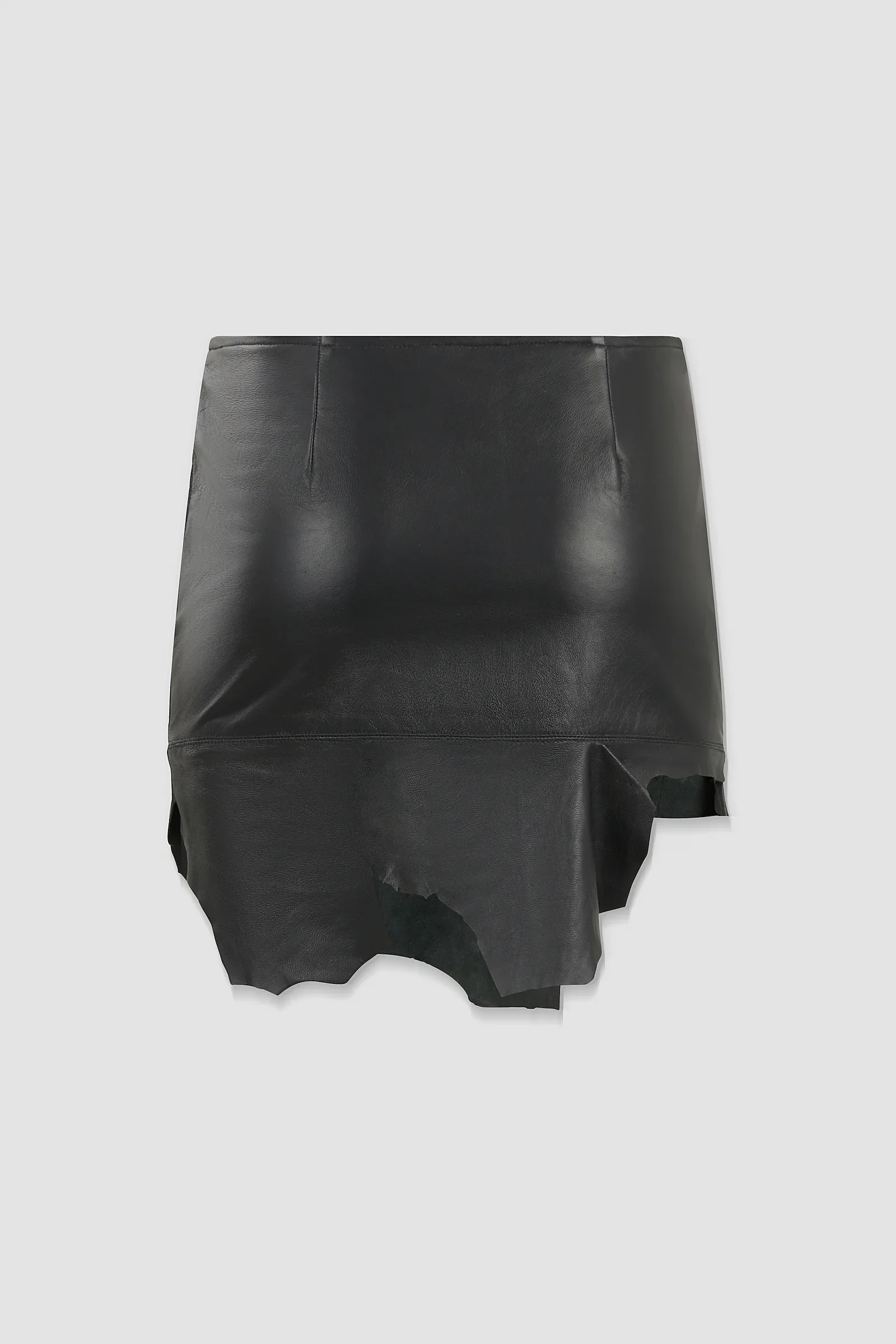 Three-quarter: Angled view of the ‘Euryale’ leather micro mini skirt showing the panelled construction and irregular leather edges.