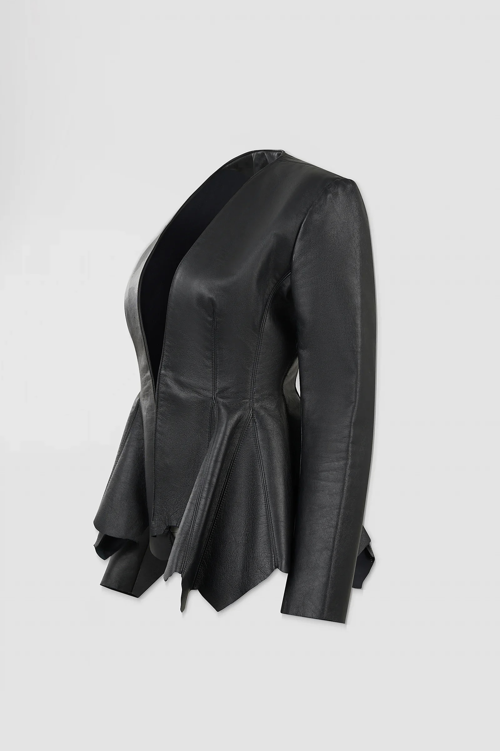 Three-quarter: Side view of the ‘Euryale’ leather jacket showing its fitted tailoring, structured shoulders and flared, irregular leather panels.