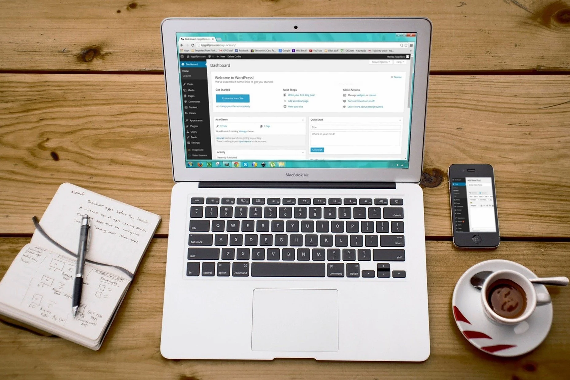 Laptop, notepad, smartphone and cup of coffee placed on a desk