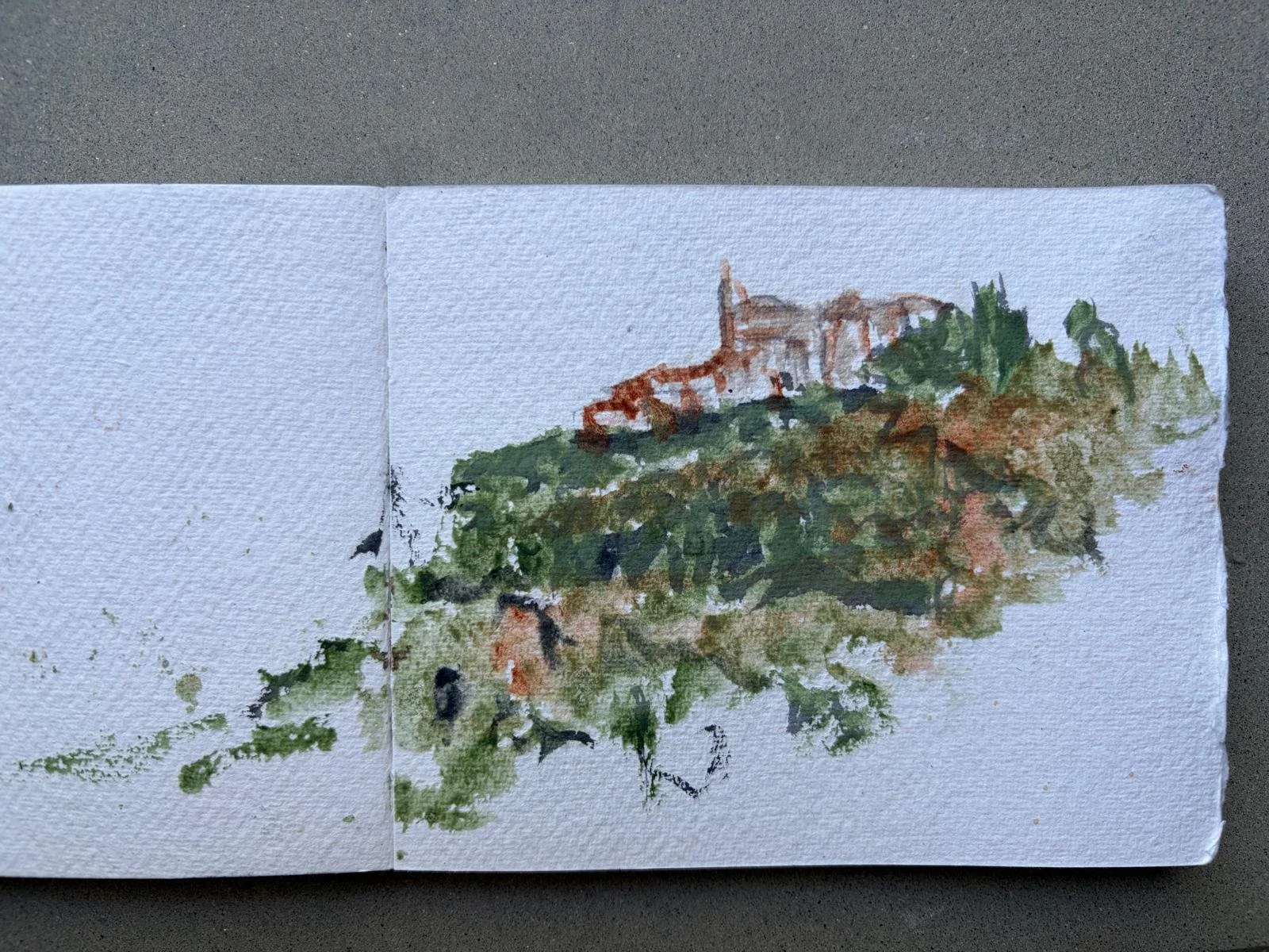 A watercolor painting of a landscape with a small building or church on a hill, surrounded by greenery and trees, on textured watercolor paper., from Charlotte Andrew Art Retreat in the Sabine Hills, Italy.