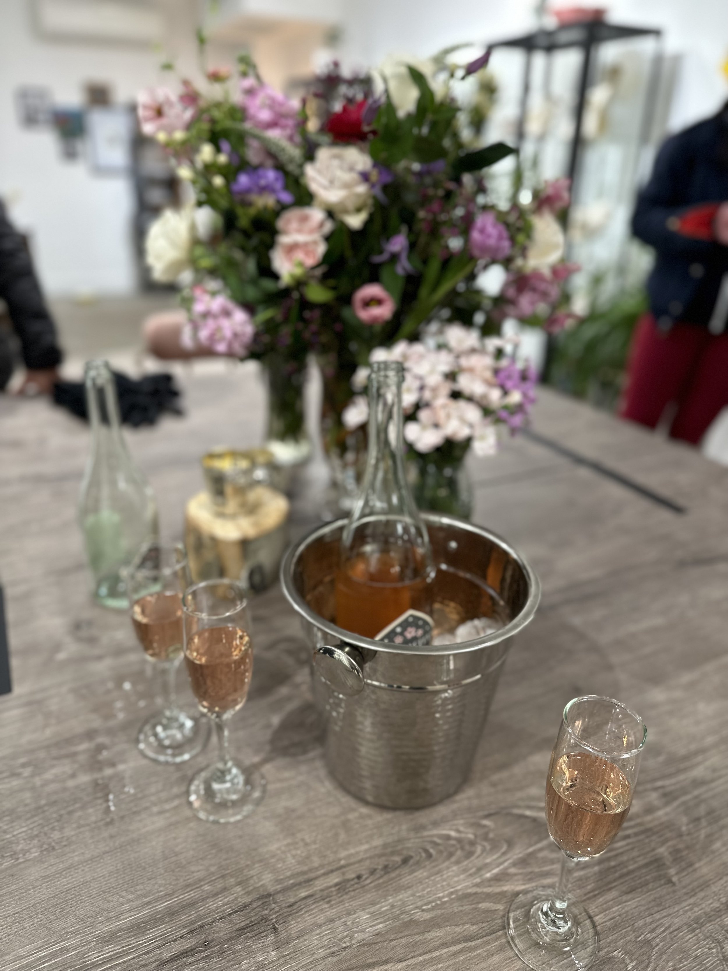 Celebratory table with rosé champagne, glasses, and flowers at The Aspen Hive