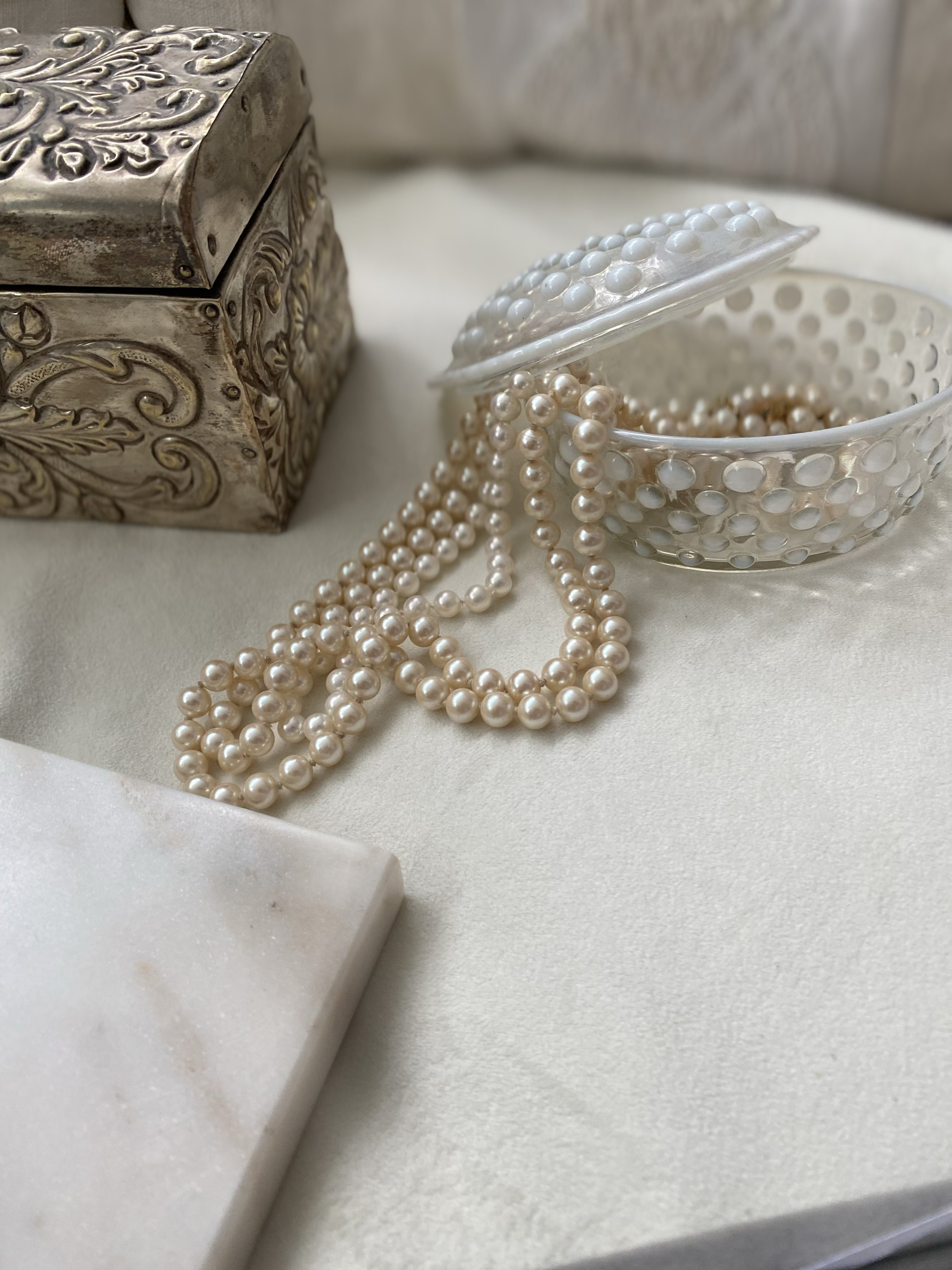 Pearl necklaces and jewelry displayed on a white marble surface at The Aspen Hive