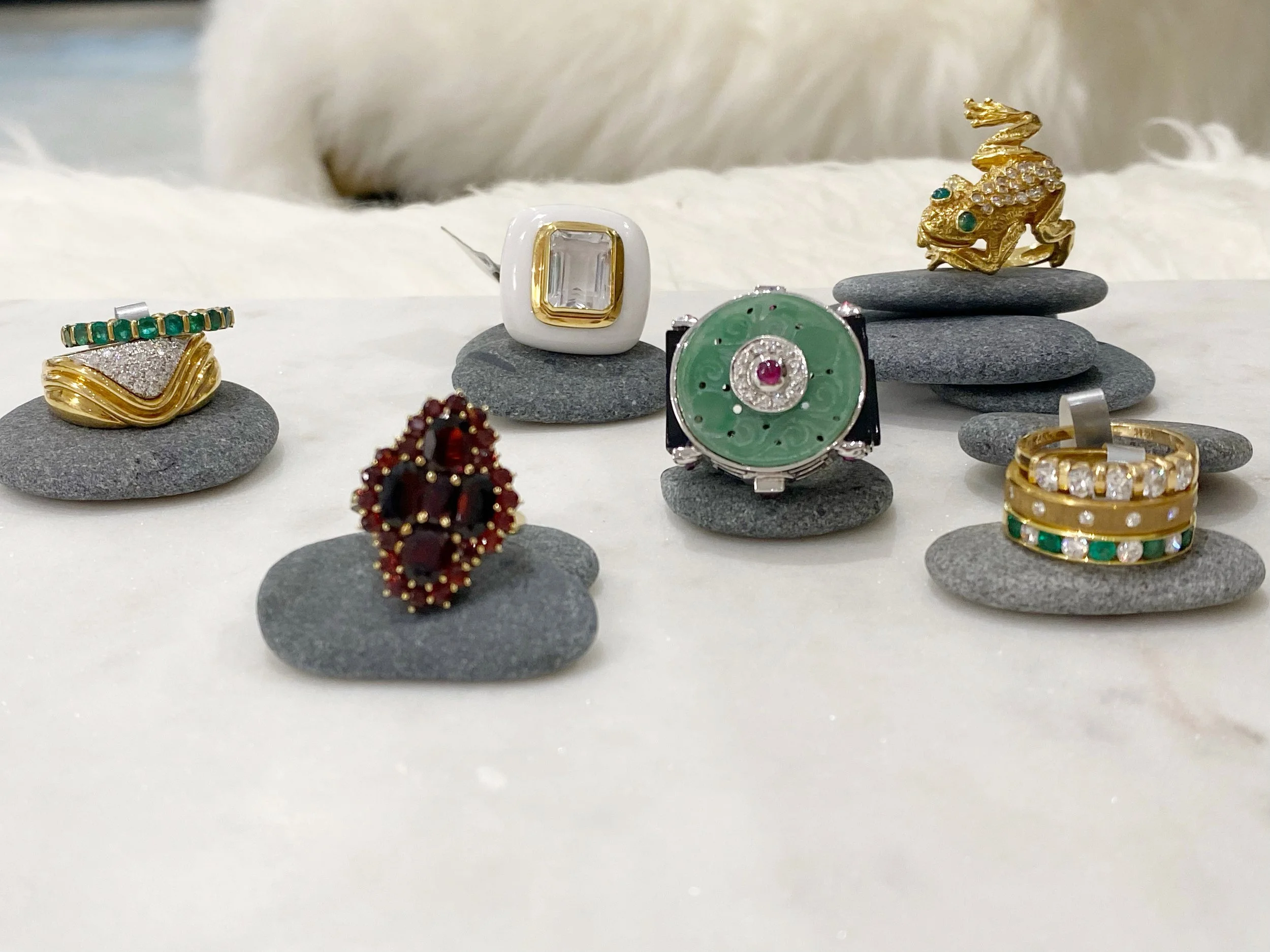 Curated vintage jewelry collection featuring gold rings, diamonds, emeralds, and colorful gemstones