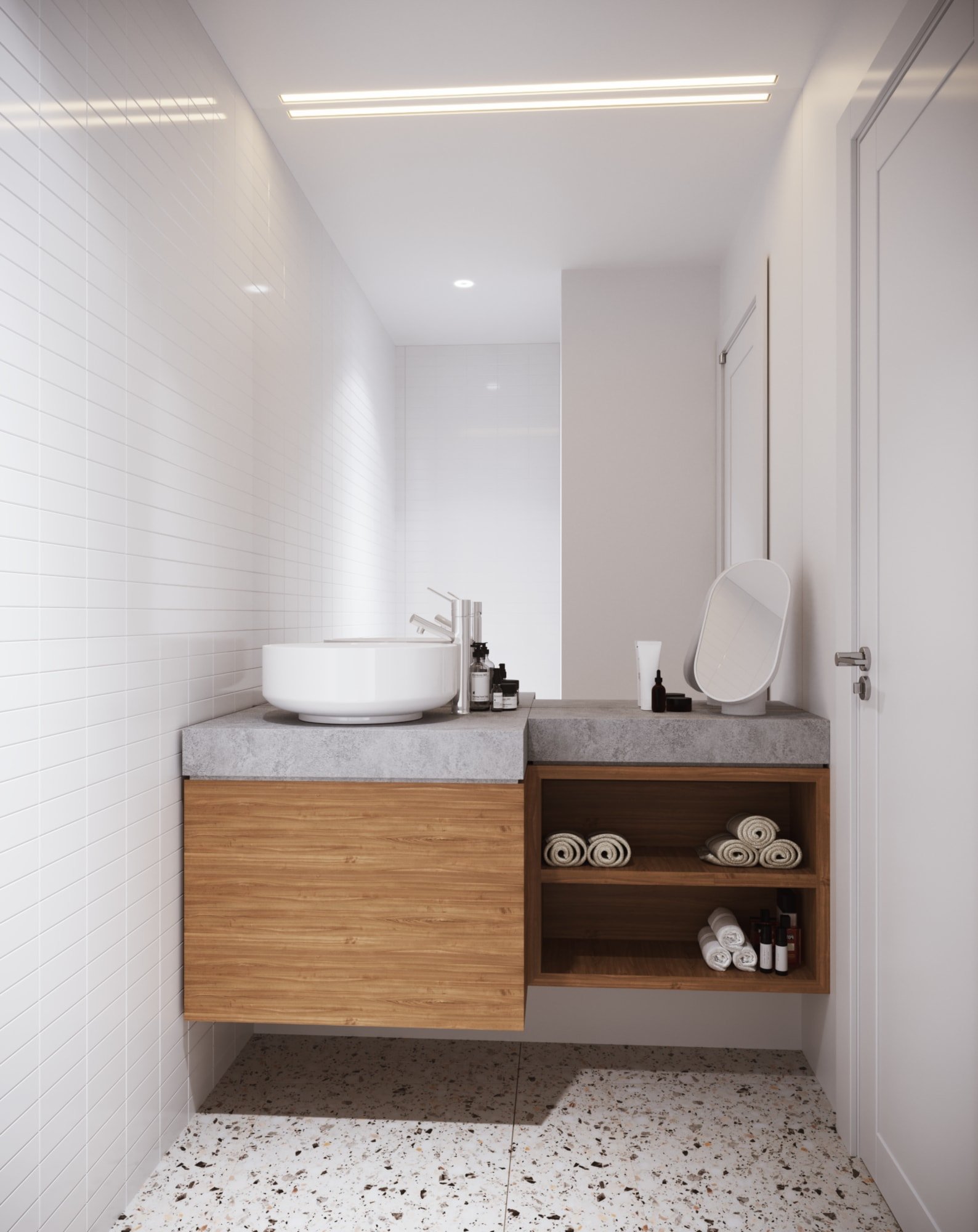 Modern minimalist bathroom with a floating wooden vanity, a round white vessel sink, and a concrete countertop. Open shelves contain rolled towels and toiletries. White tile walls and terrazzo flooring are visible.