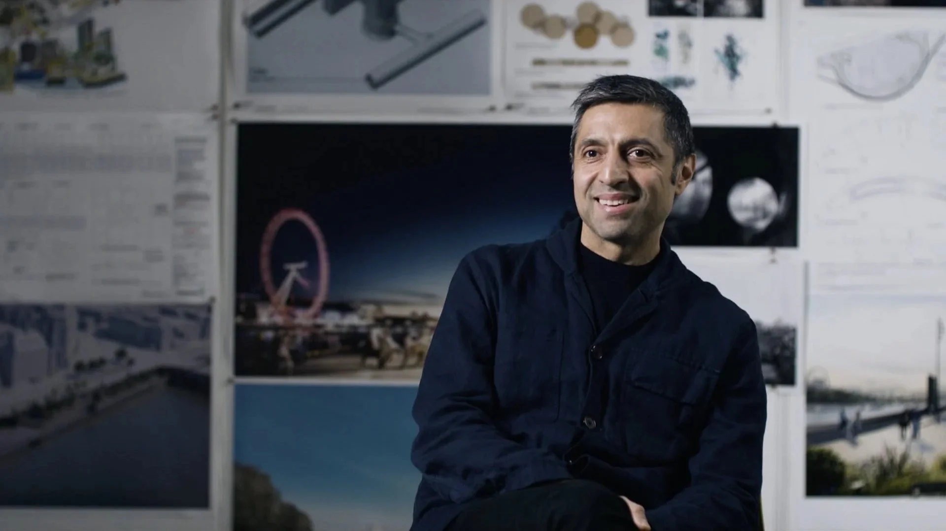 Hawkins/Brown lead architect interview — designer smiling in studio with
London Eye imagery and design drawings pinned behind, Thames Tideway
film
