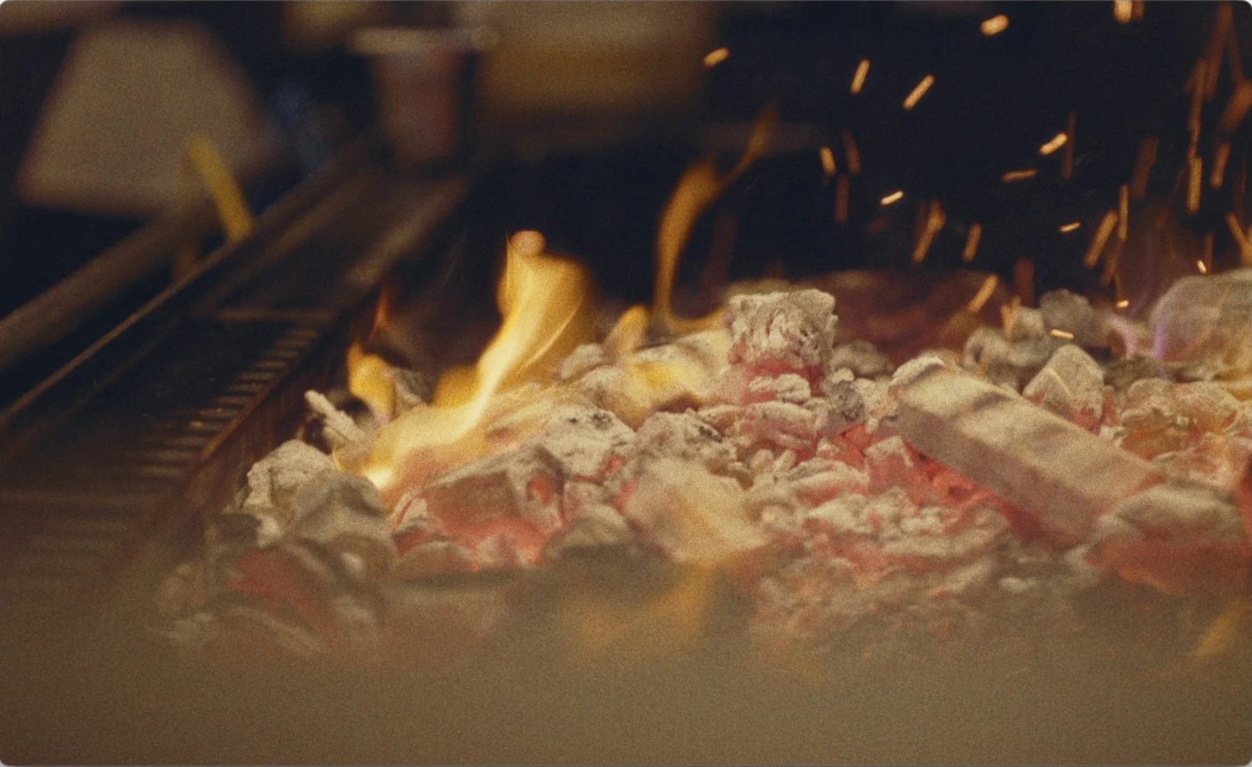 Wood fire grill with sparks and glowing embers at Mountain restaurant Soho, 16mm
film still by James Dougan