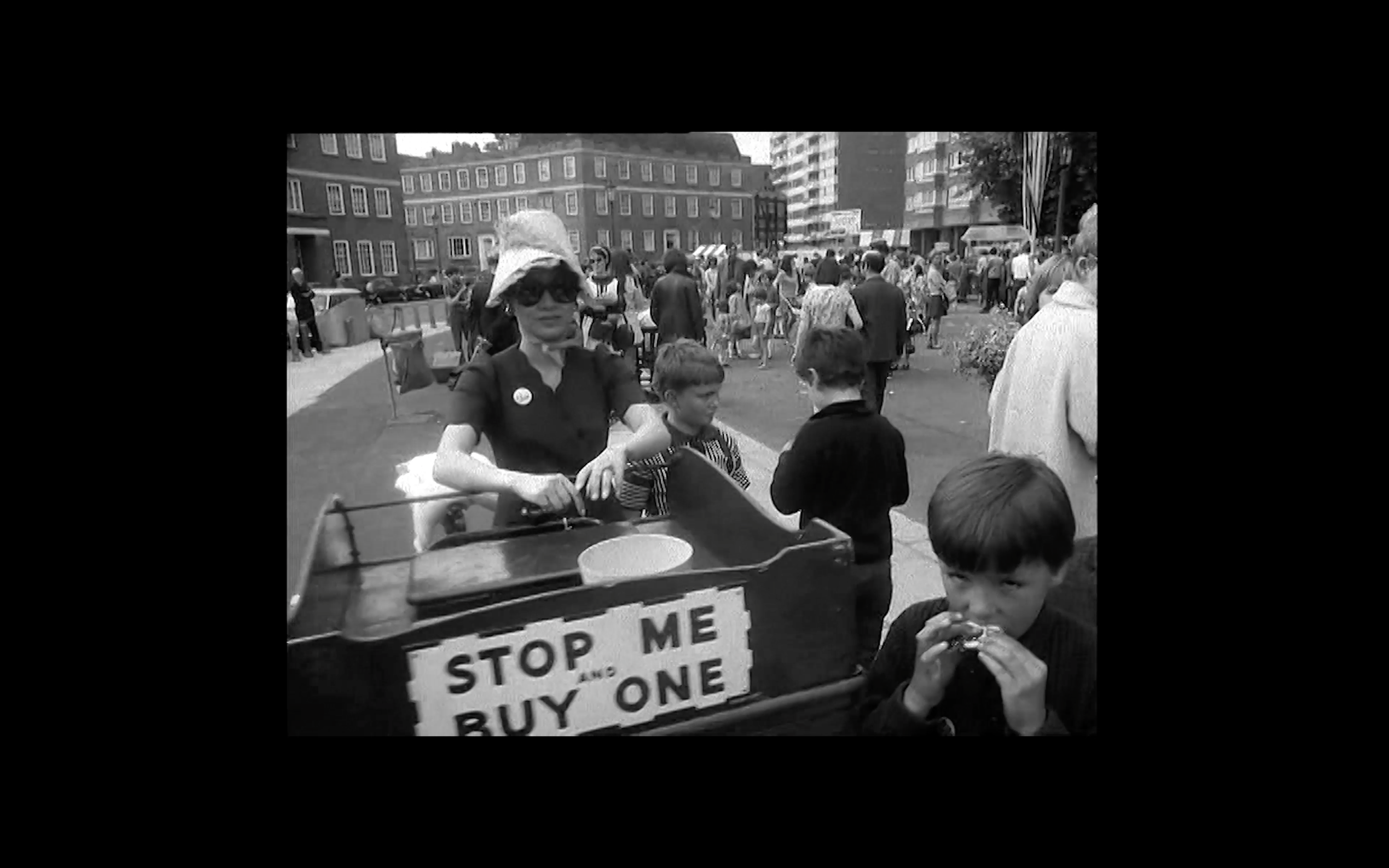 Archival street footage capturing everyday community life on the Isle of Dogs, grounding the film in local history and lived experience.