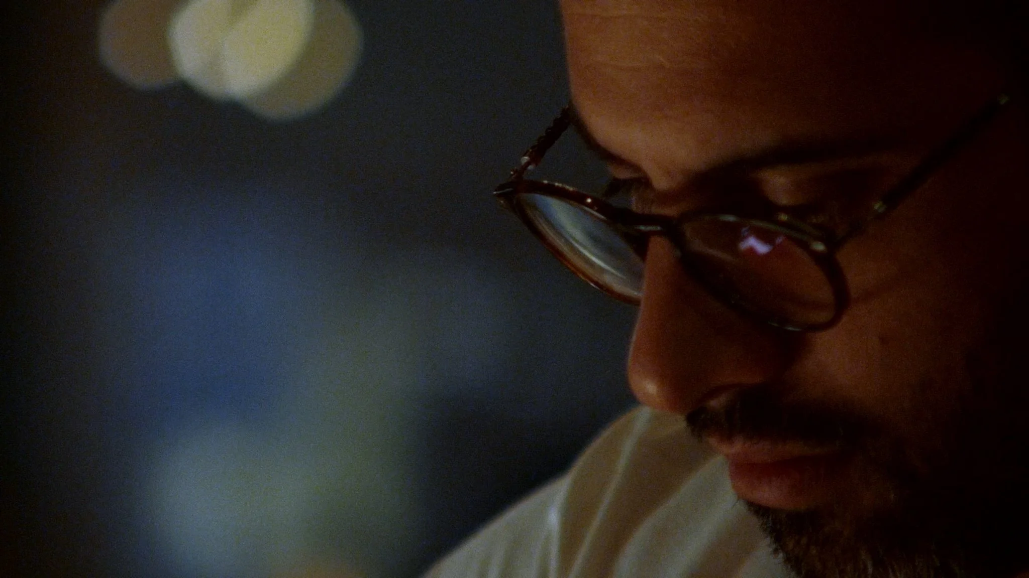 A quiet portrait of a chef in the kitchen, filmed in low light to preserve atmosphere and focus.