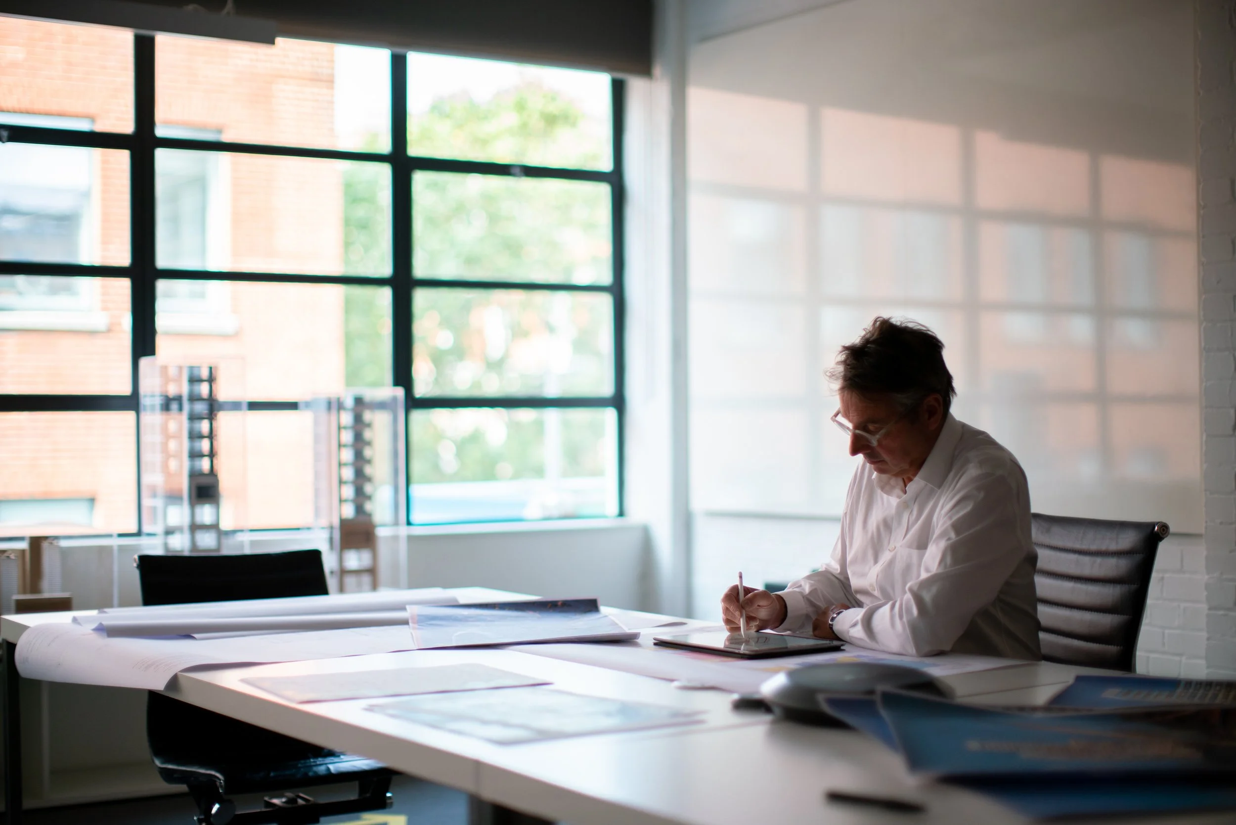 An architect working through drawings and ideas during filming for a branded architectural documentary, focusing on creative process and development thinking.